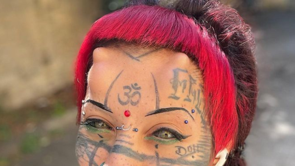 Tvár má plnú piercingov a tetovaní