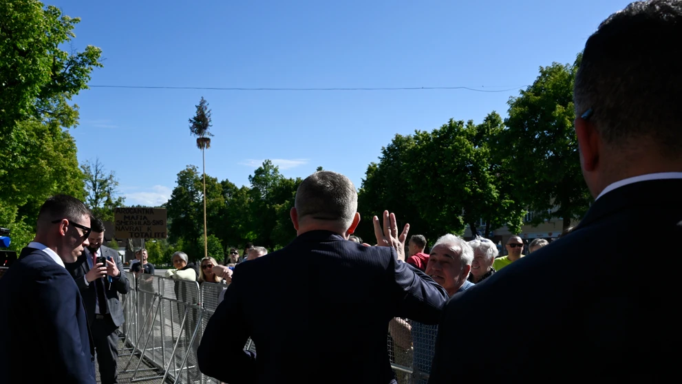 Na snímke uprostred predseda vlády SR Robert Fico (Smer-SD) zdraví miestnych obyvateľov počas príchodu na výjazdové rokovanie vlády v Handlovej.