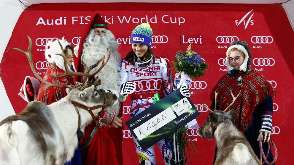 Petra Vlhová sa usmieva na pódiu so živými sobmi po prvom triumfe v slalome vo fínskom Levi z roku 2017.