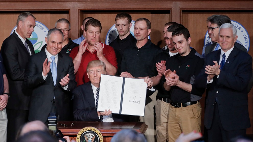 Americký prezident Donald Trump drží podpísaný dekrét.