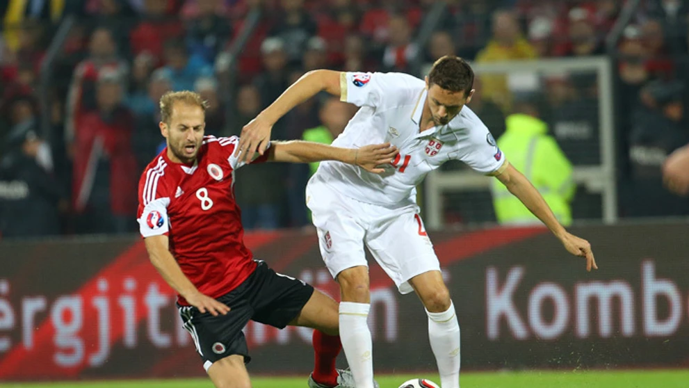  Srbský hráč Nemanja Matič (vpravo) v súboji  s Albáncom Migjenom Bashom v kvalifikácii na ME 2016.