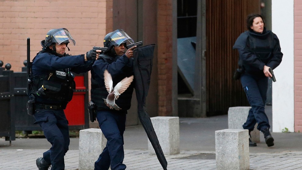 Na kombosnímke policajti (hore) zasahujú po teroristických útokoch na parížskom predmestí Saint-Denis 18. novembra 2015 a dole d