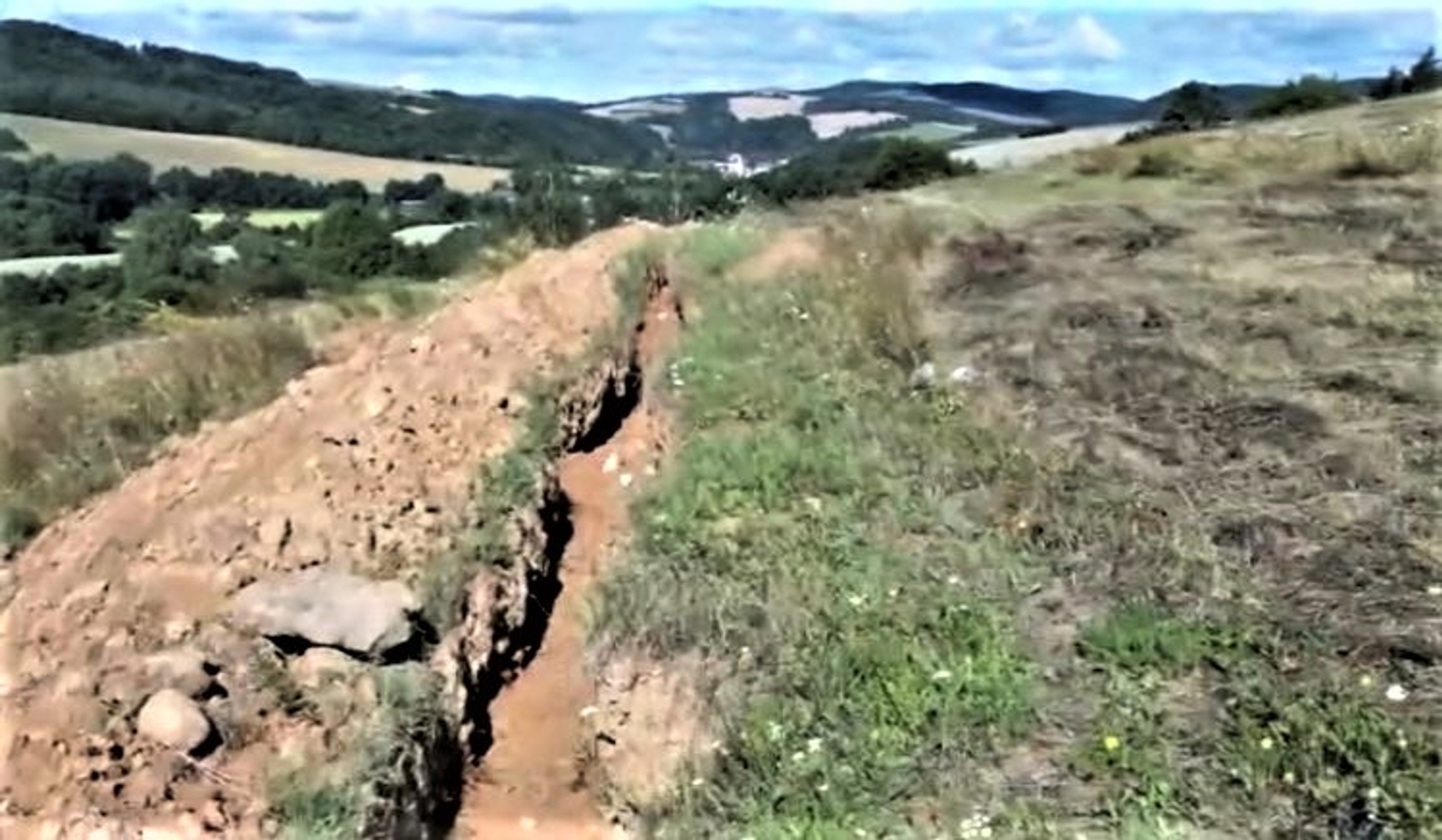 Dlhé jamy po vykopaných kábloch pri obci Kojatice.