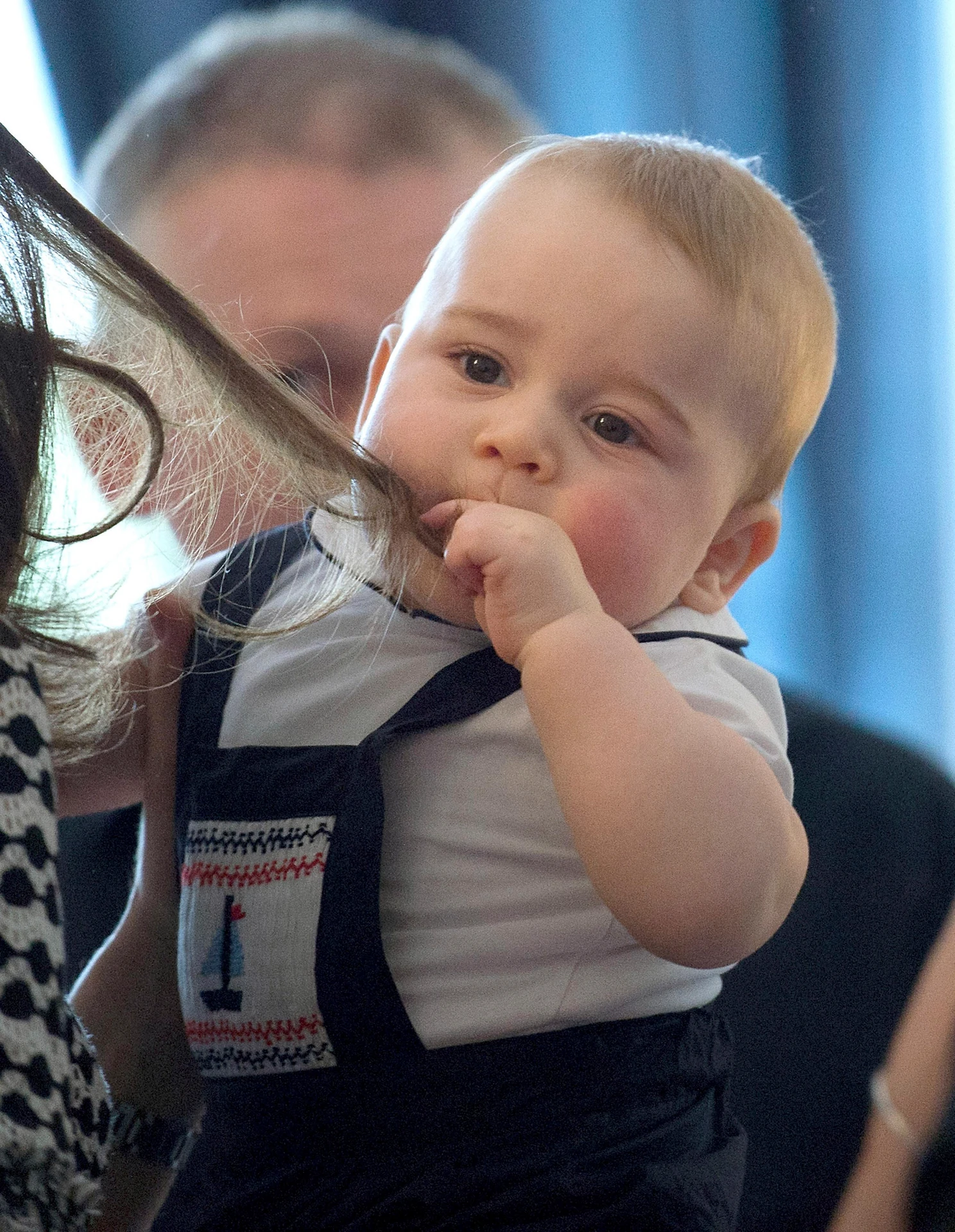 Britský princ George sa hrá s vlasmi Kate 9. apríla 2014.