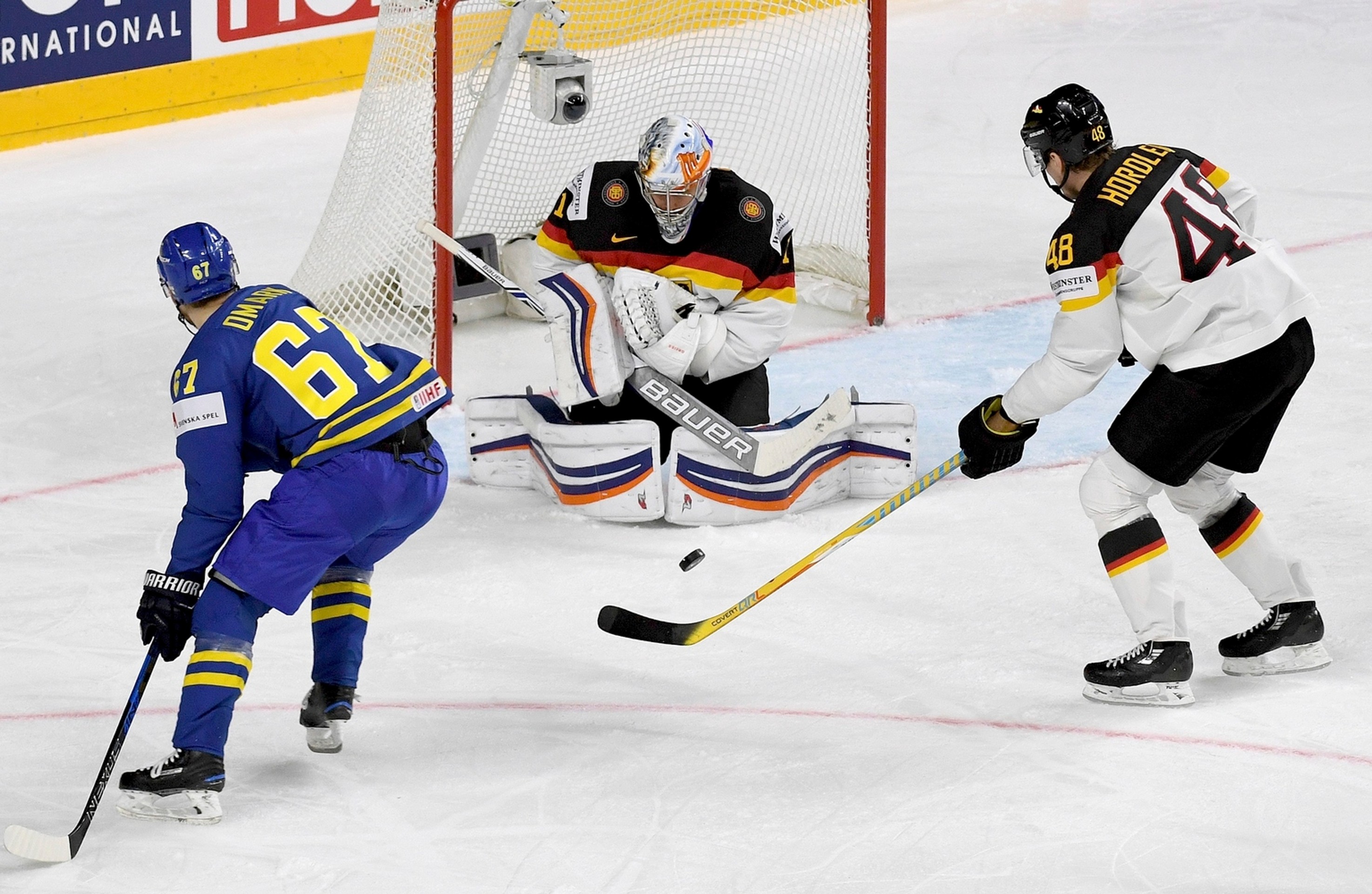 Nemecký brankár Thomas Greiss blokuje strelu Švéda Linusa Omarka.