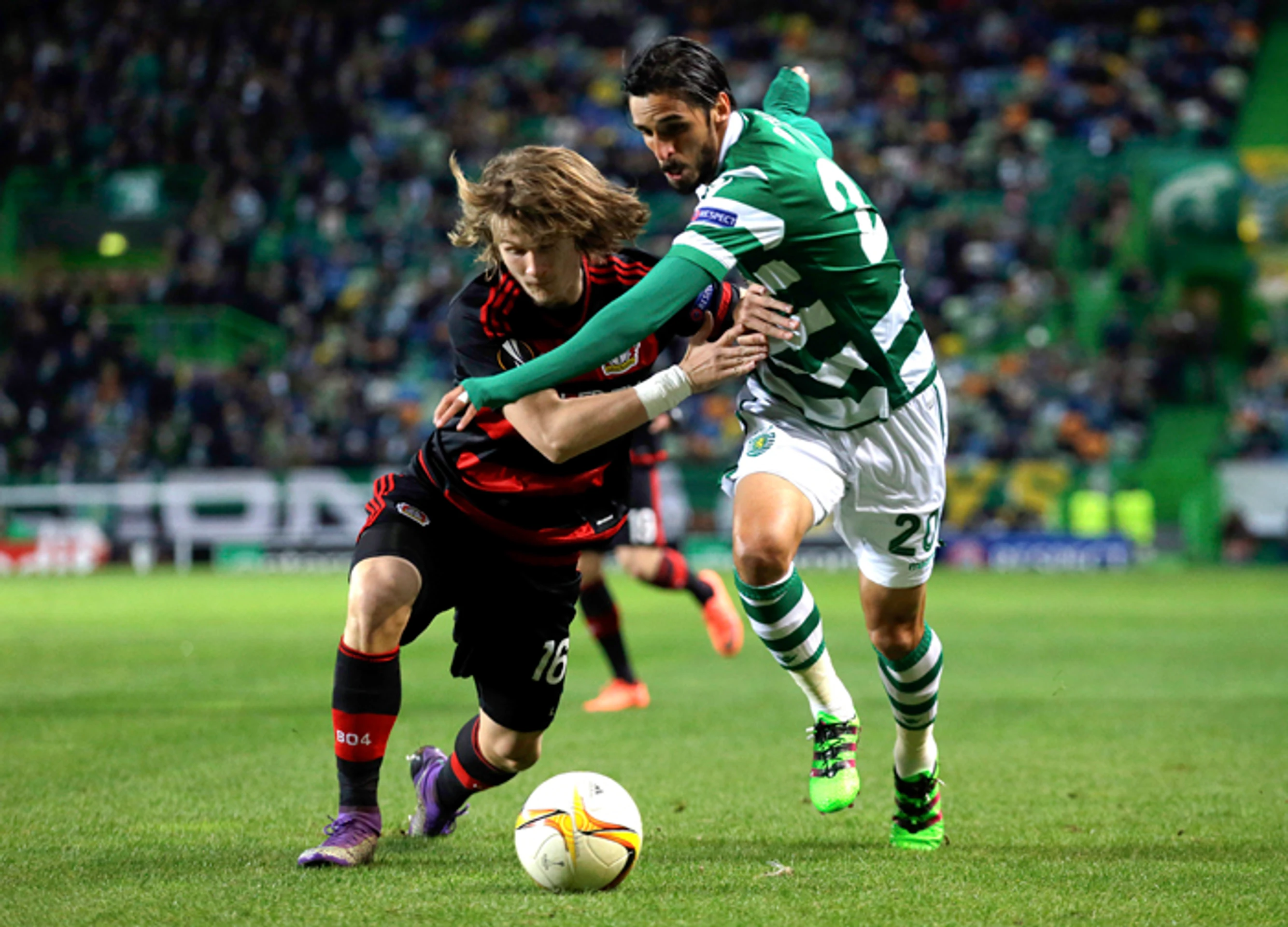 Vľavo Tin Jedvaj (Leverkusen) a Bryan Ruiz (Sporting) bojujú o loptu v prvom zápase 16-finále EL UEFA.