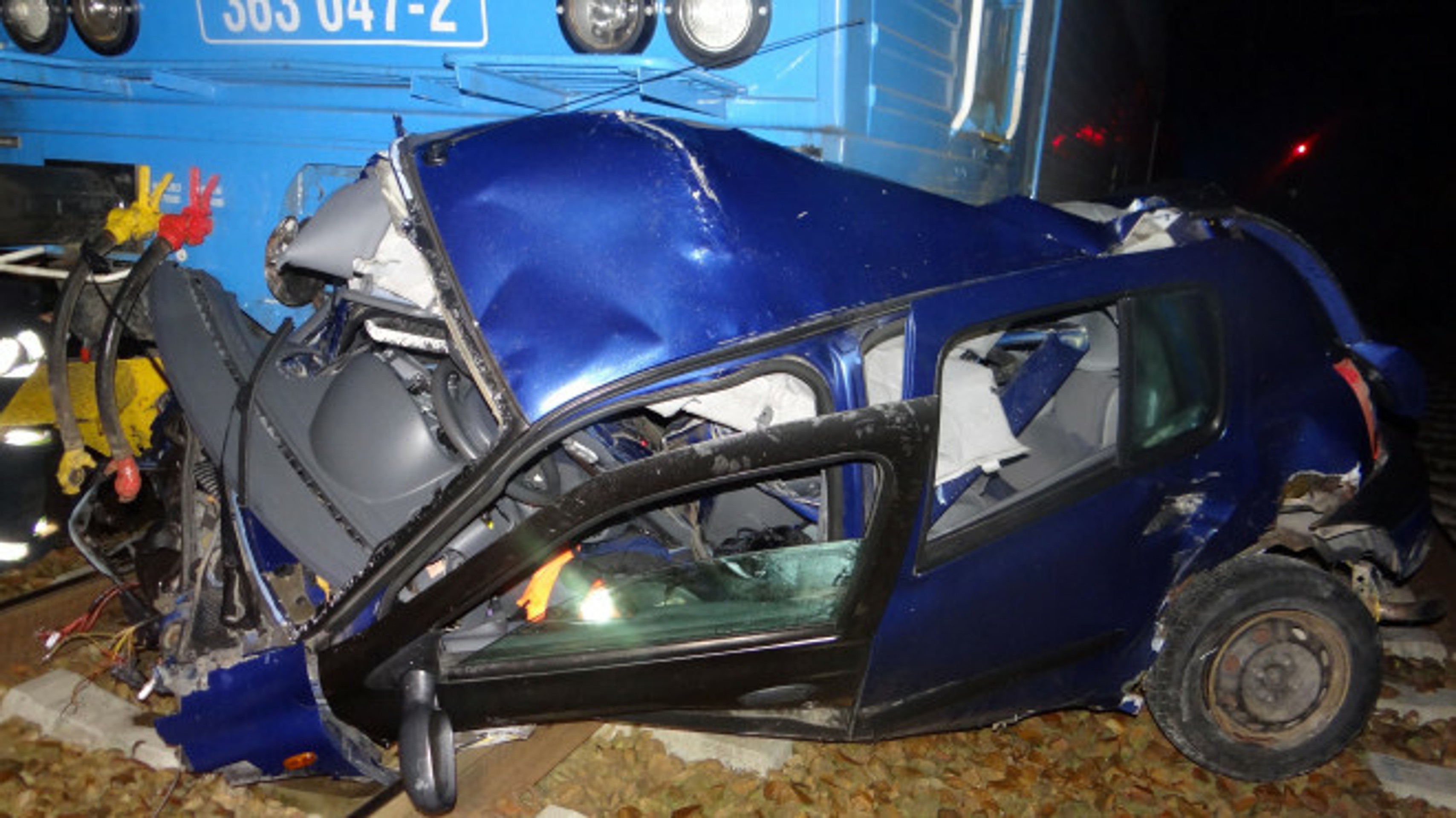 Zošrotované auto vlakom na trati v obci Kařízek na Rokycansku.