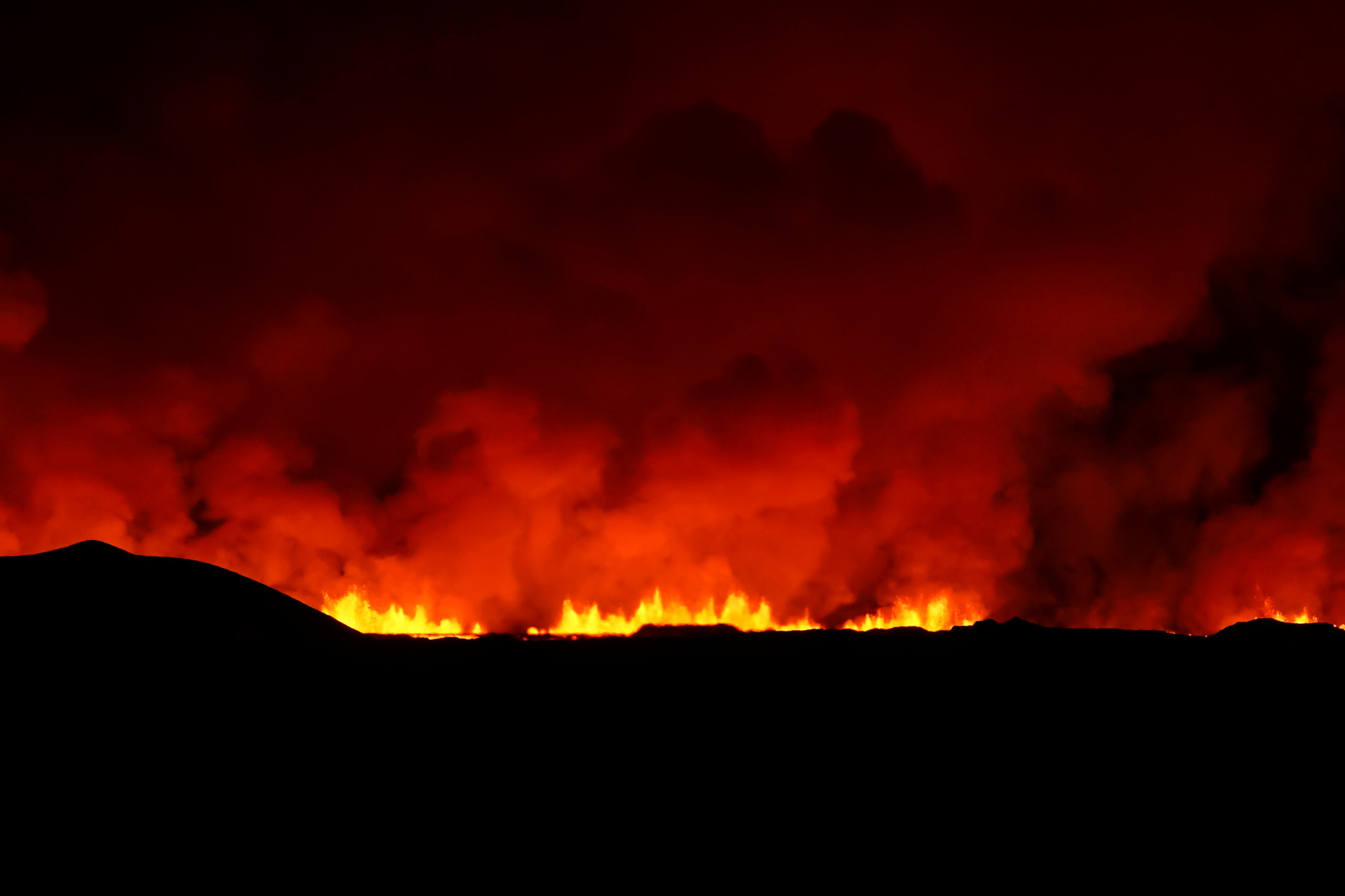Dym stúpa po erupcii sopky, ku ktorej došlo severne od prístavného mesta Grindavík na polostrove Reykjanes