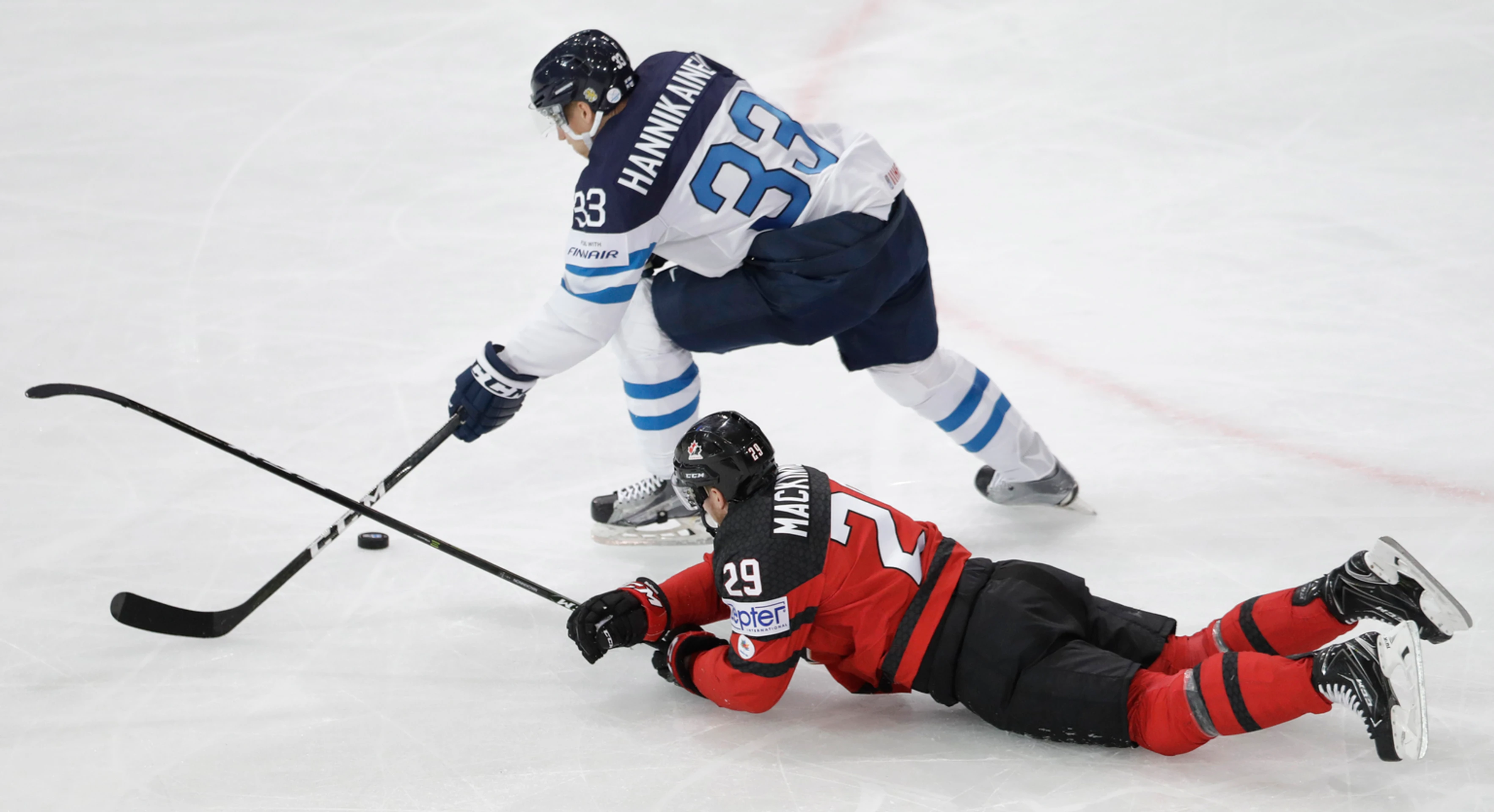 Nathan Mackinnon (dole) z Kanady sa snaží v zápase MS 2017 zastaviť Fína Markusa Hannikainena.