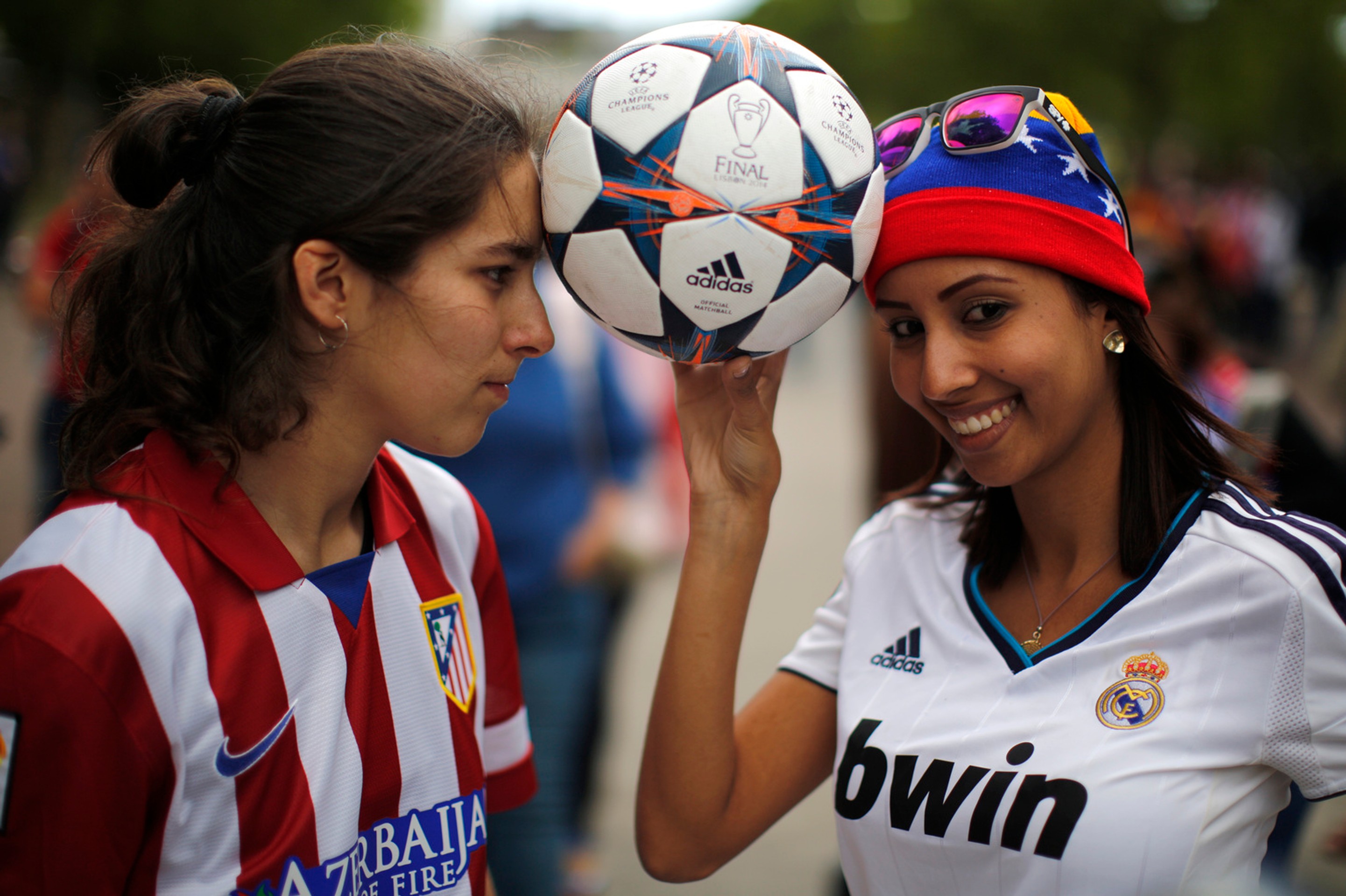 Fanúšička Realu Madrid (vpravo) a Atletica Madrid (vľavo) pózujú s futbalovou loptou pred začiatkom finále Ligy majstrov v Lisab