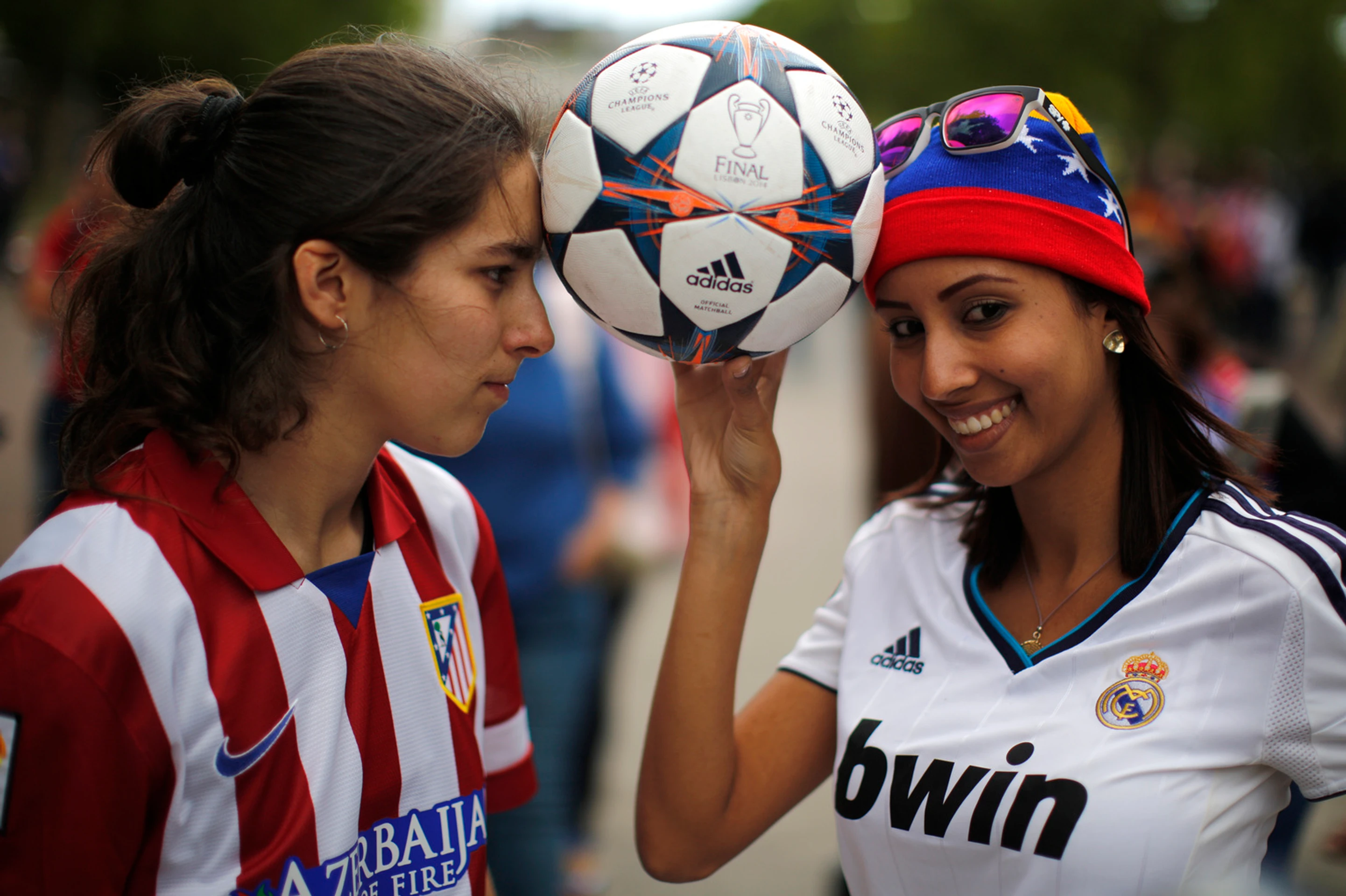 Fanúšička Realu Madrid (vpravo) a Atletica Madrid (vľavo) pózujú s futbalovou loptou pred začiatkom finále Ligy majstrov v Lisab