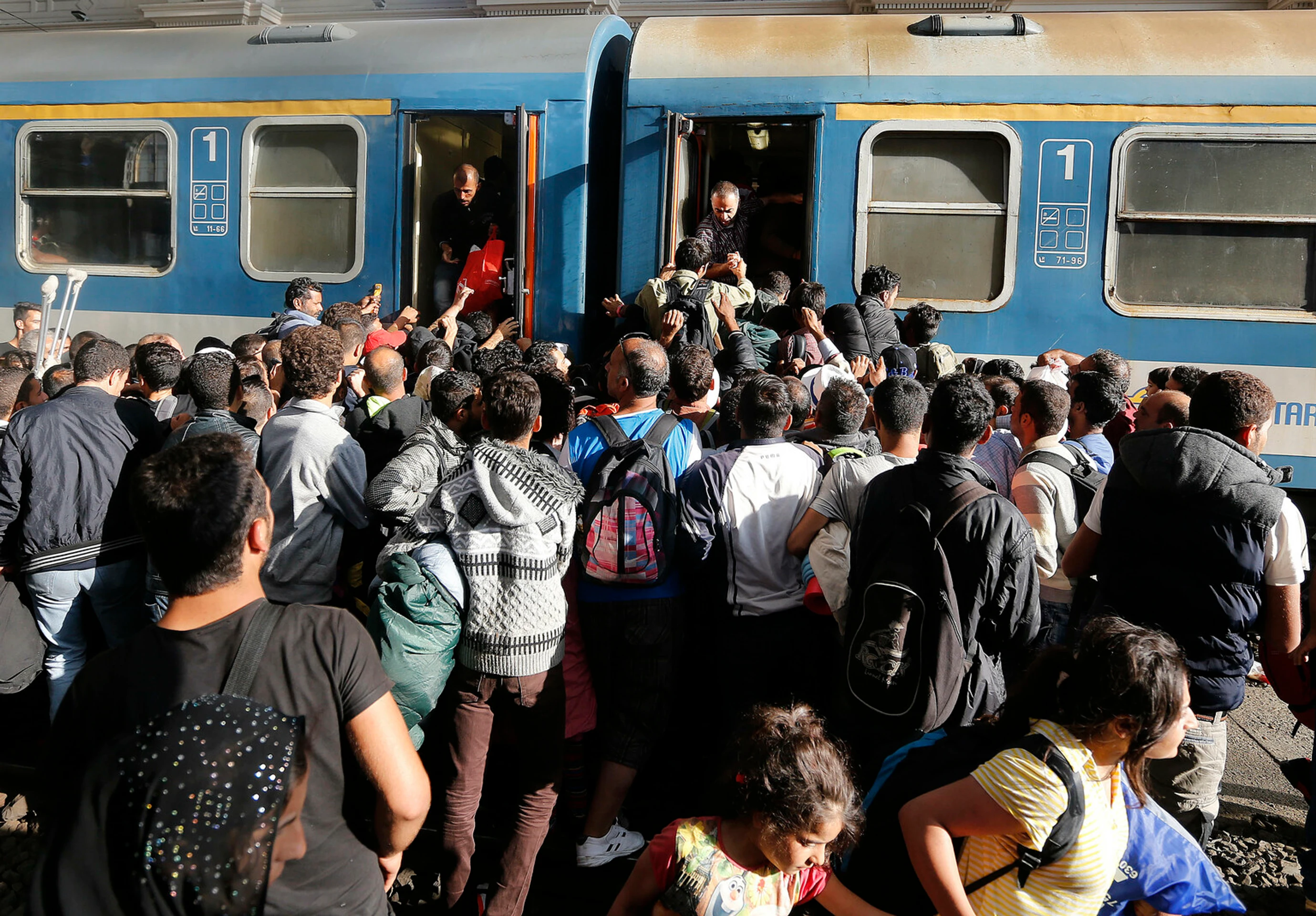 Migranti sa snažia nastúpiť do vlaku v Budapešti.