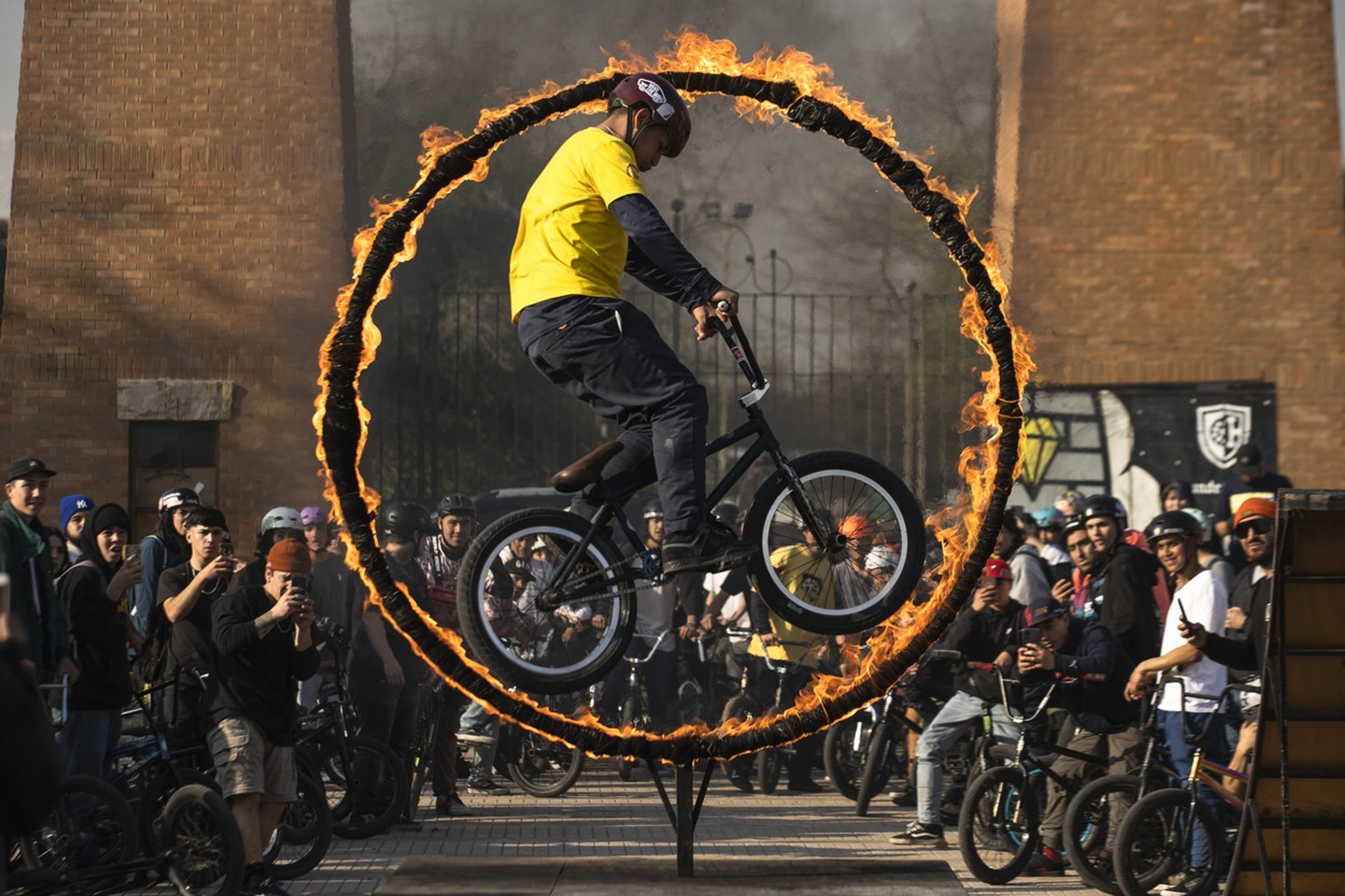 Cyklista predvádza trik počas skoku cez horiacu obruč na podujatí BMX Day v čilskom Santiagu.