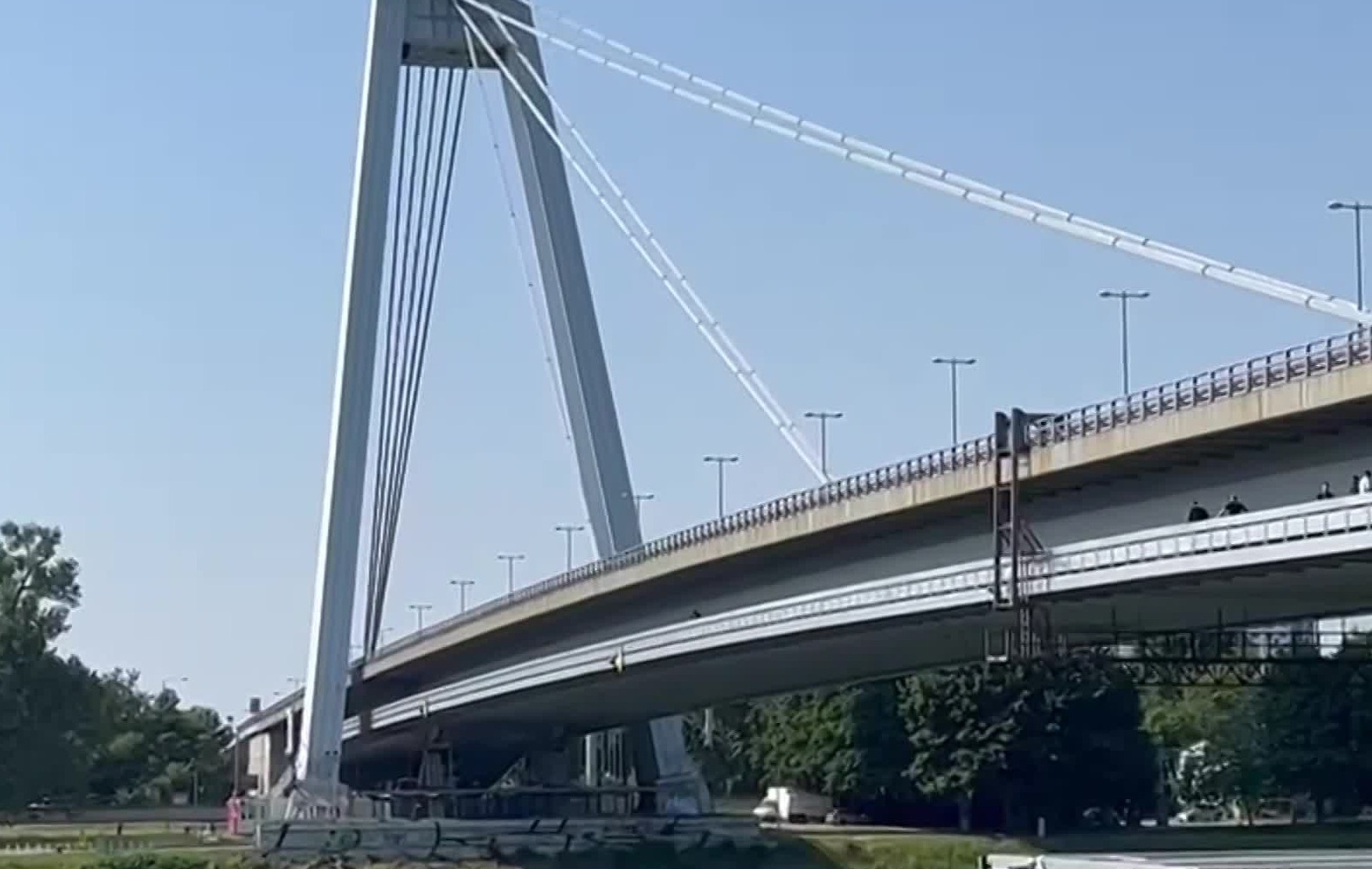 Muž sedí na zábradlí Mosta SNP