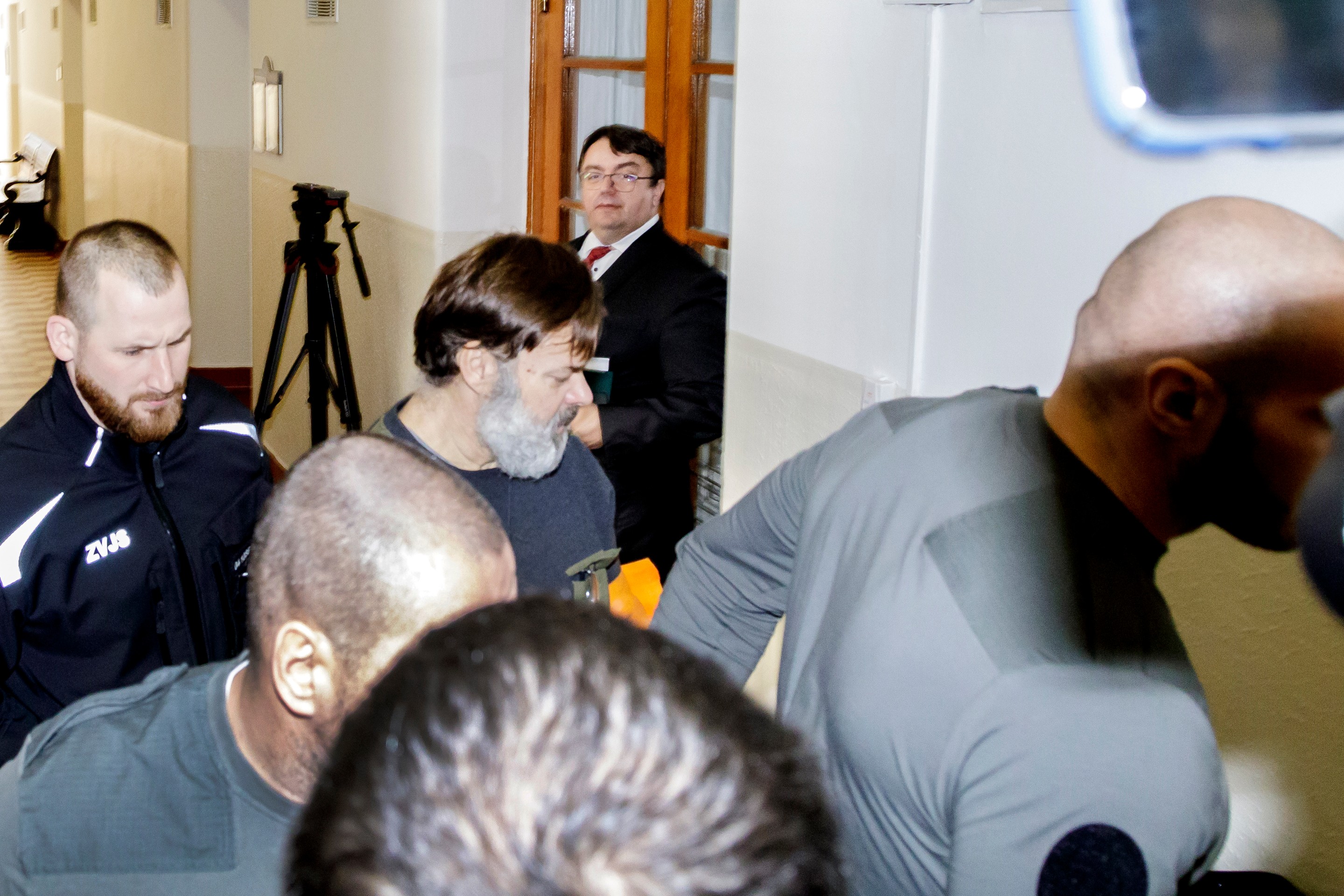 Dušan Dědeček prichádza v sprievode členov Zboru väzenskej a justičnej stráže prichádza do súdnej siene na Okresnom súde Bratislava I v stredu 25. januára 2023.