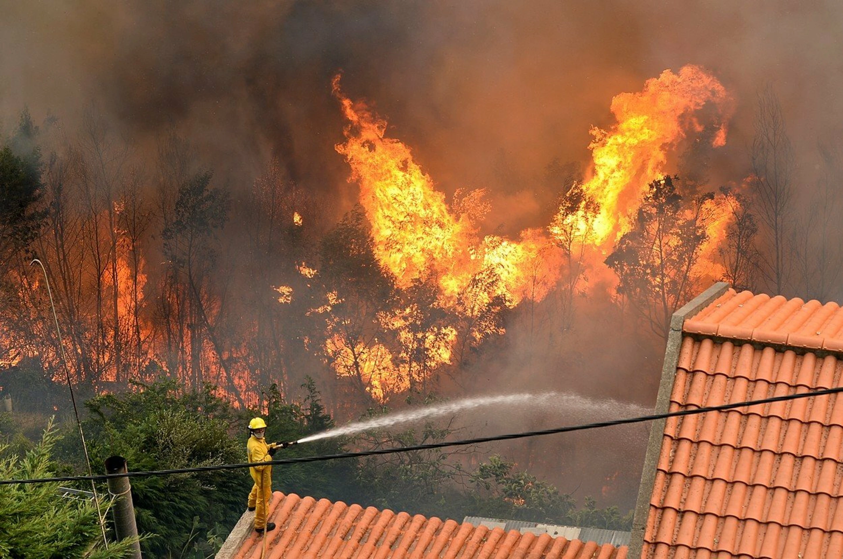 Šľahajúce plamene a bezmocný požiarnik.