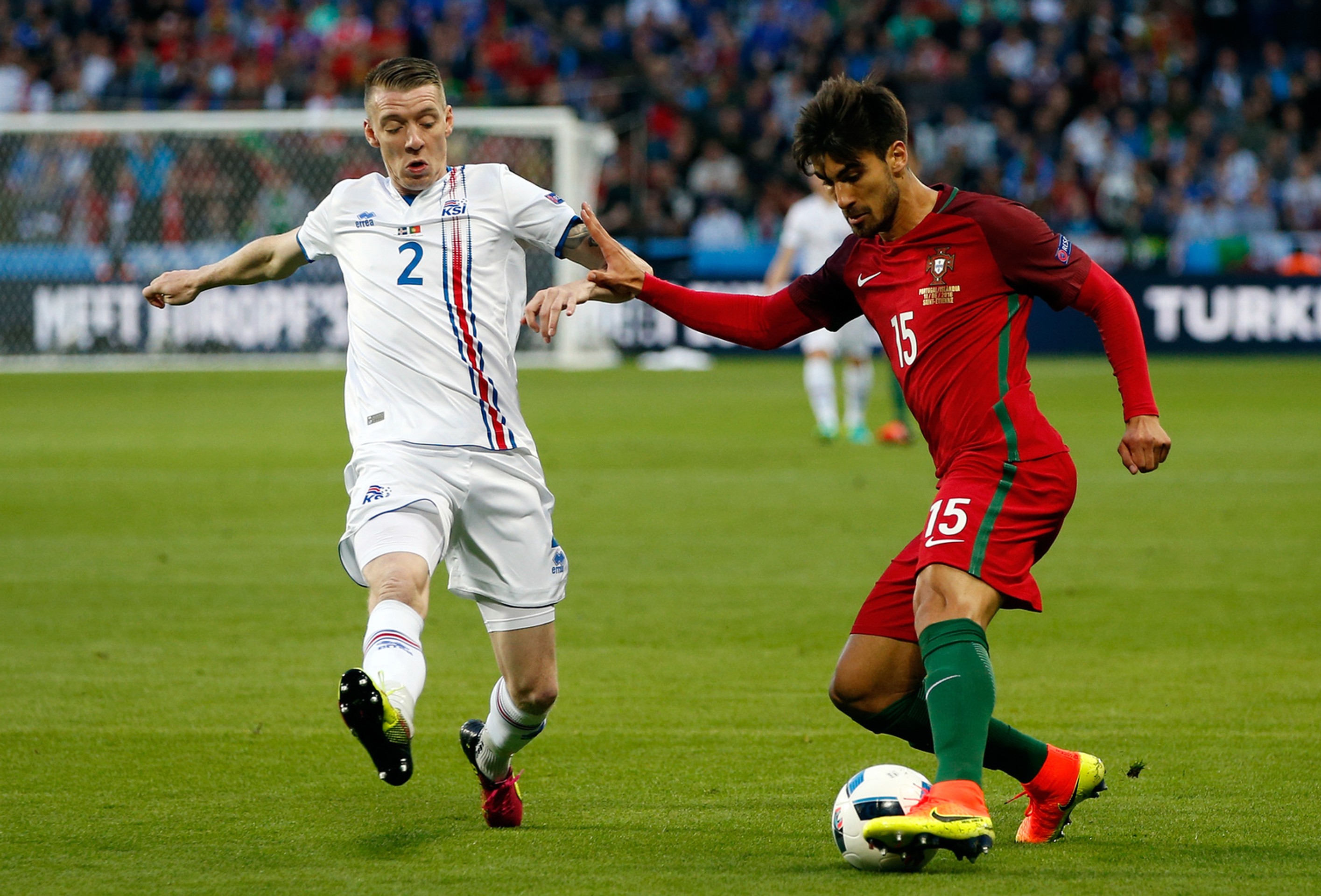 Portulčan Andre Gomes (vpravo) v obkľúčení Islanďana Birkira Saevarssona vo vzájomnom dueli na ME vo Francúzsku.