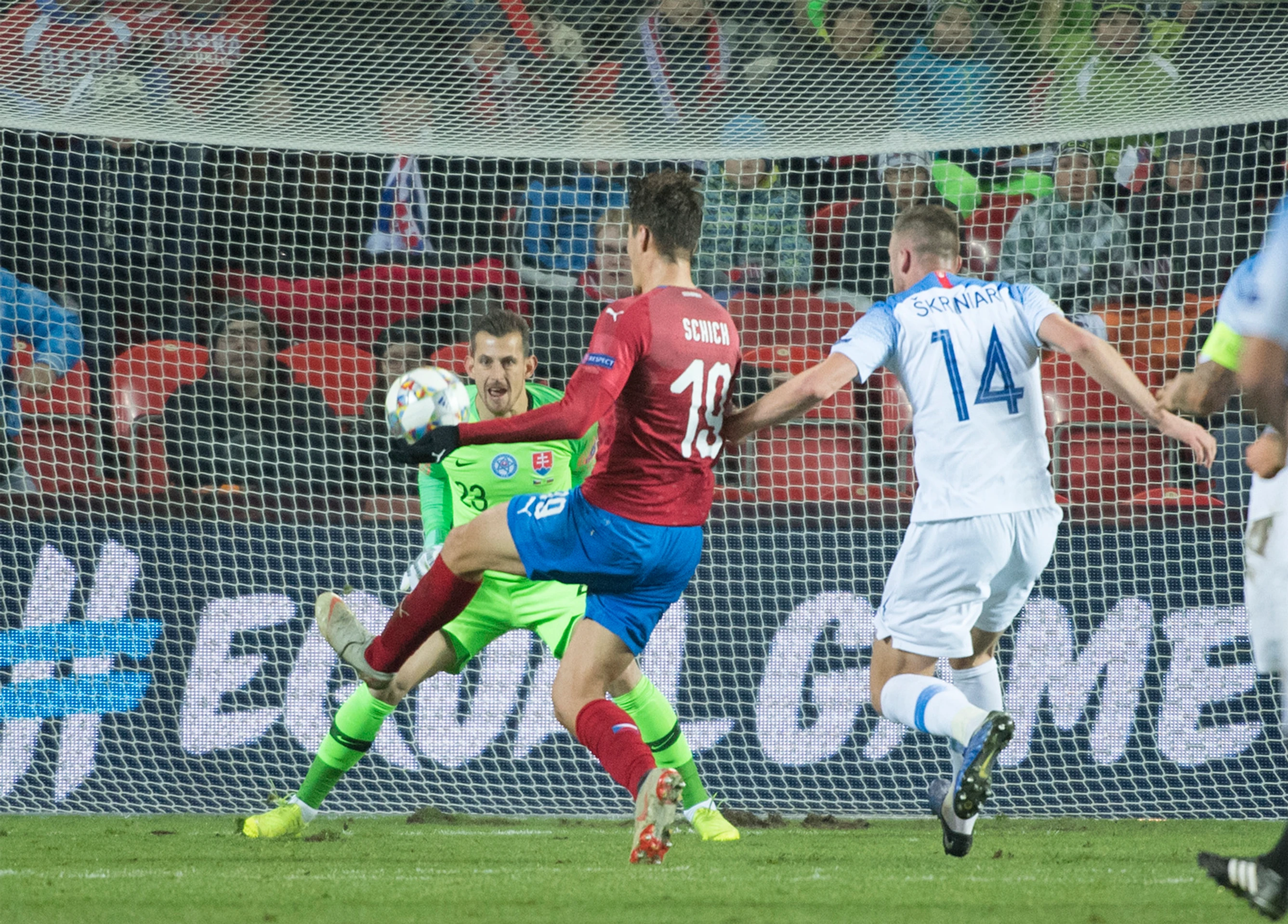 Vľavo slovenský brankár Martin Dúbravka, vpravo obranca Milan Škriniar, uprostred český útočník Patrik Schick strieľa gól.