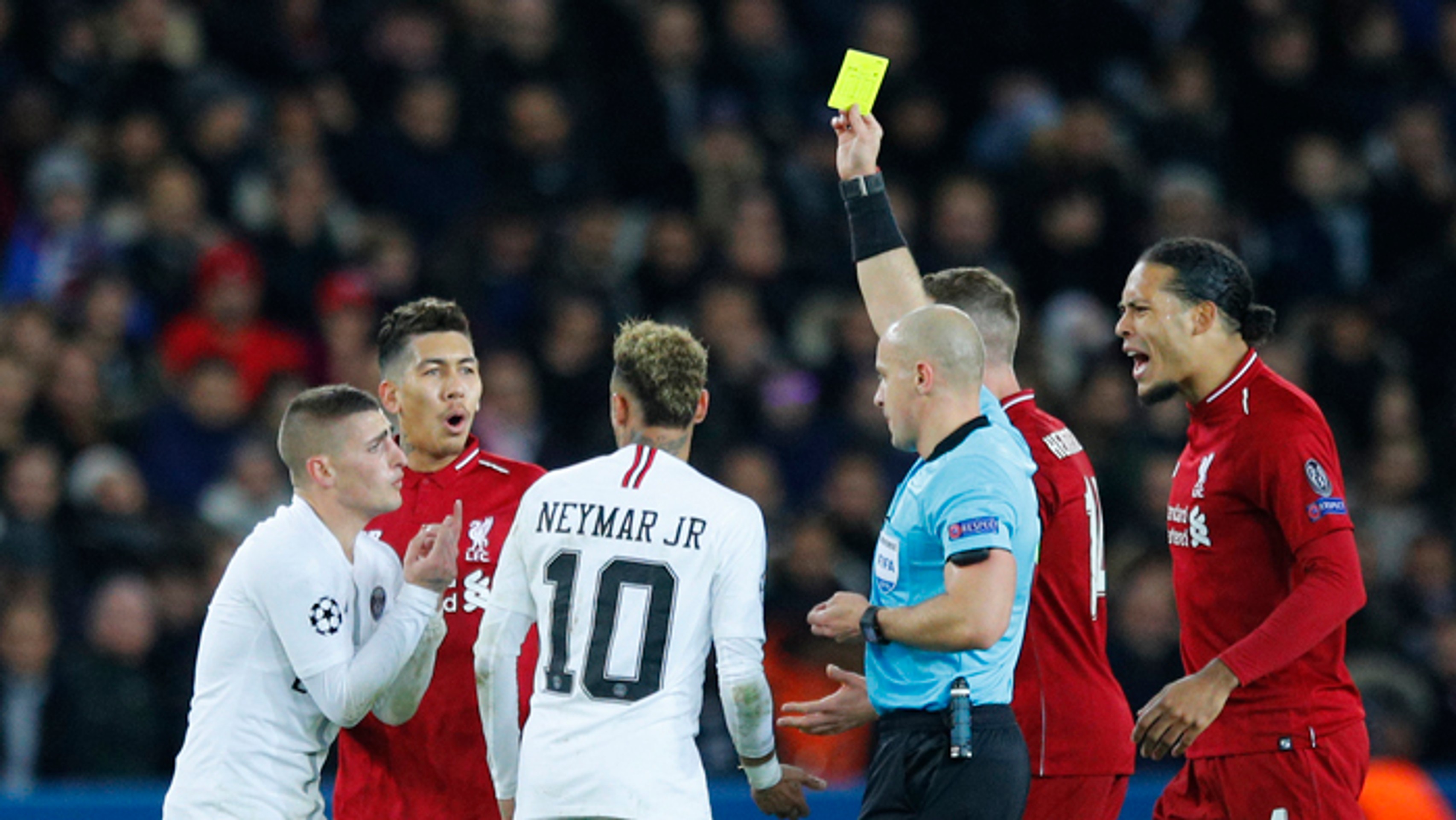  Marco Verratti (vľavo) z PSG dostáva žltú kartu v zápase LM proti FC Liverpool.