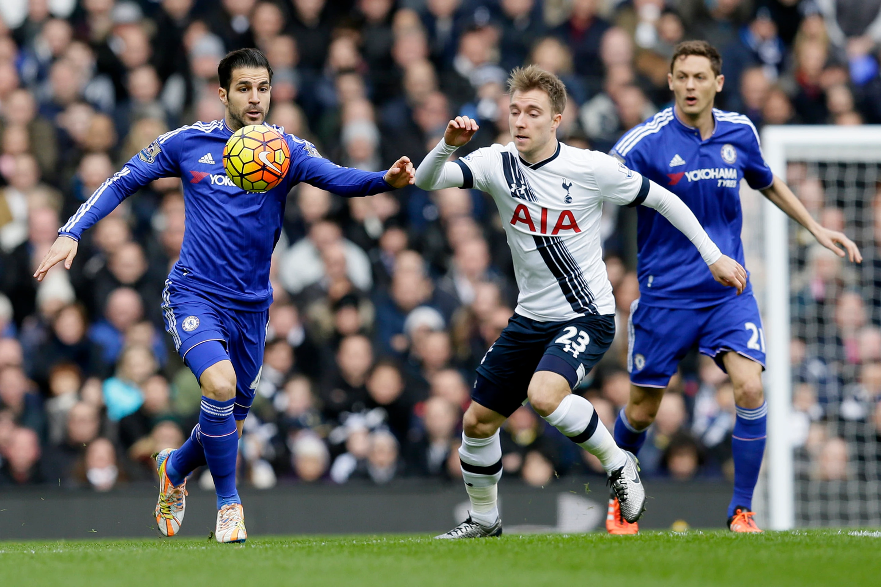 Christian Eriksen (v strede) a Cesc Fabregas (vľavo) v súboji o loptu.