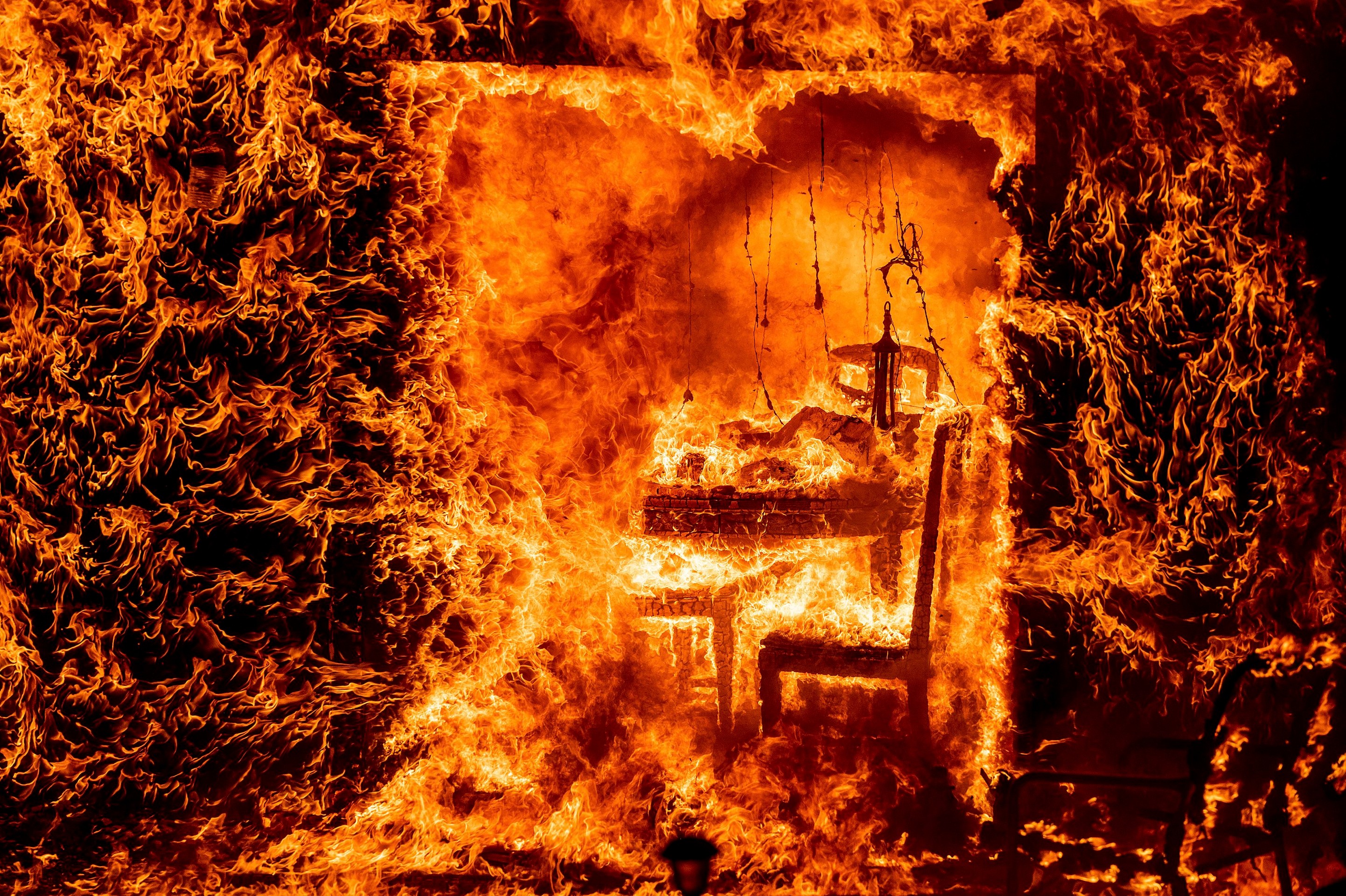 Pohľad do útrob horiaceho domu, ktorý zasiahol lesný požiar. (24. 7. 2022, Mariposa County, Kalifornia)
