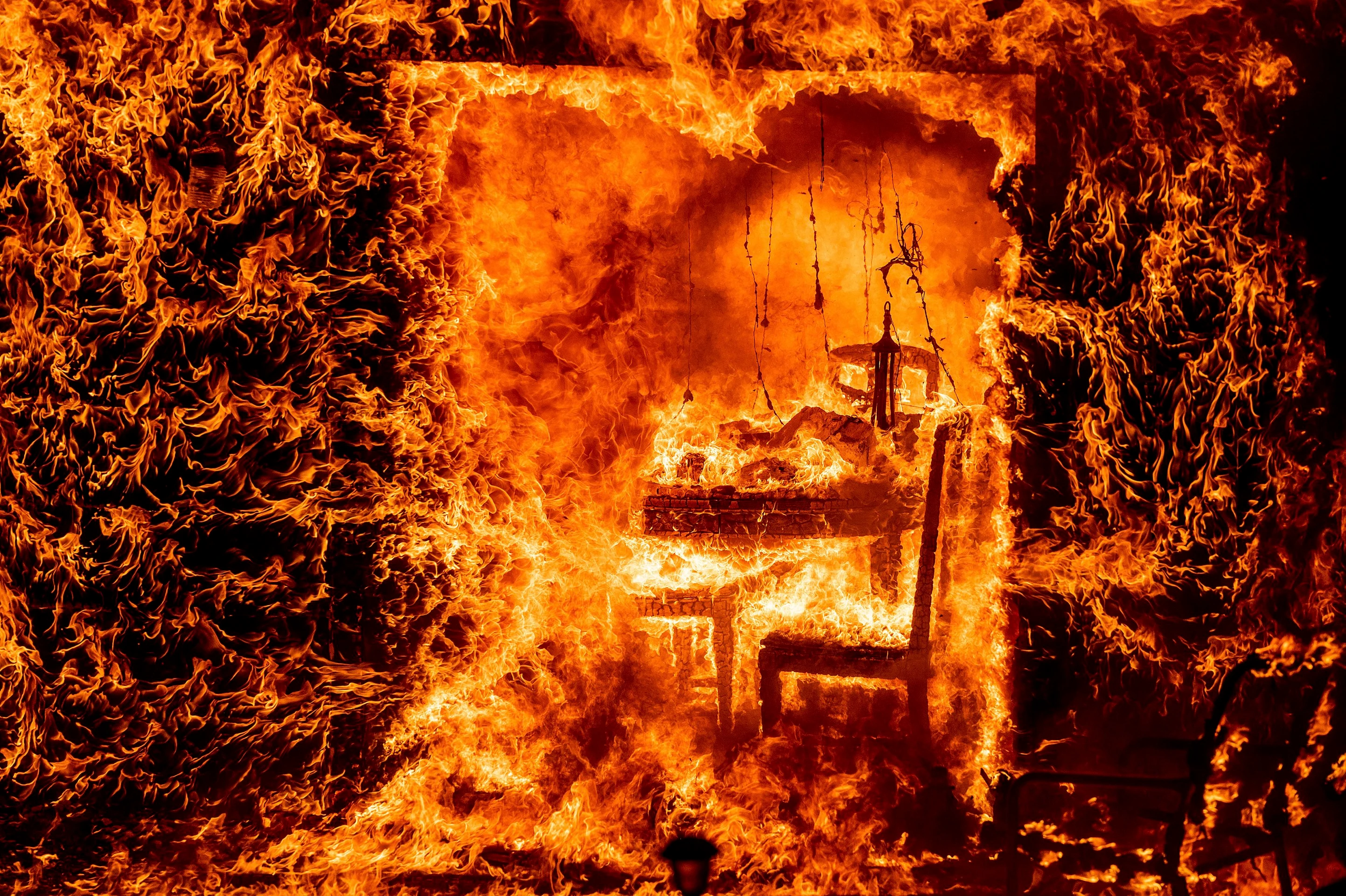 Pohľad do útrob horiaceho domu, ktorý zasiahol lesný požiar. (24. 7. 2022, Mariposa County, Kalifornia)
