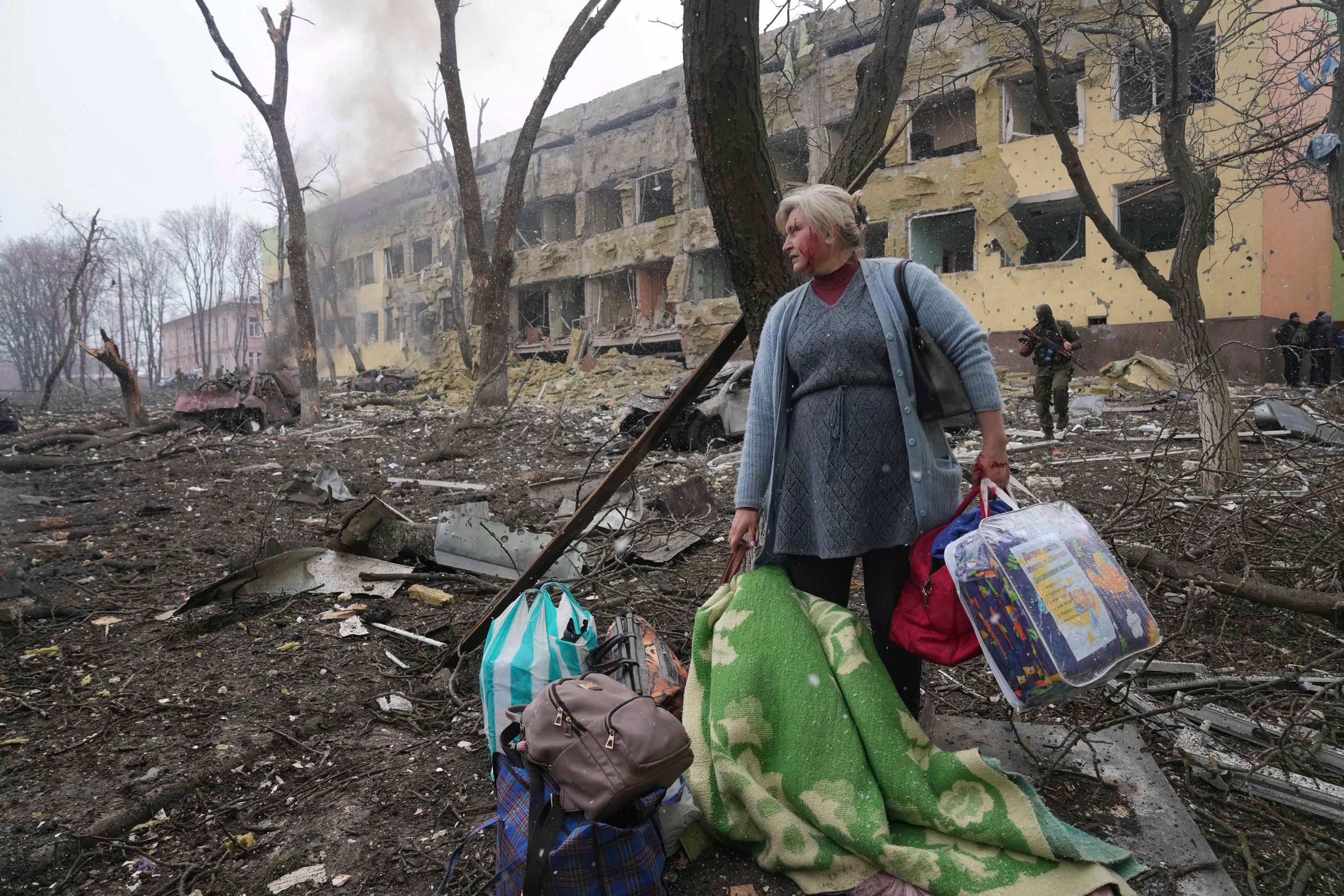 Žena pred bombami zničenou pôrodnicou v Mariupole.