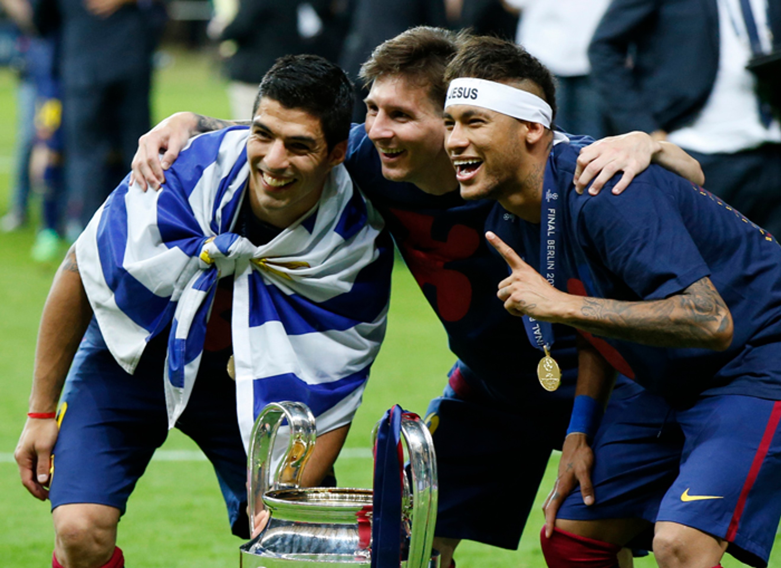 Útočné trio FC Barcelona Luis Suarez, Lionel Messi a Neymar pózujú fotografom pred trofejou pre víťaza Ligy majstrov.