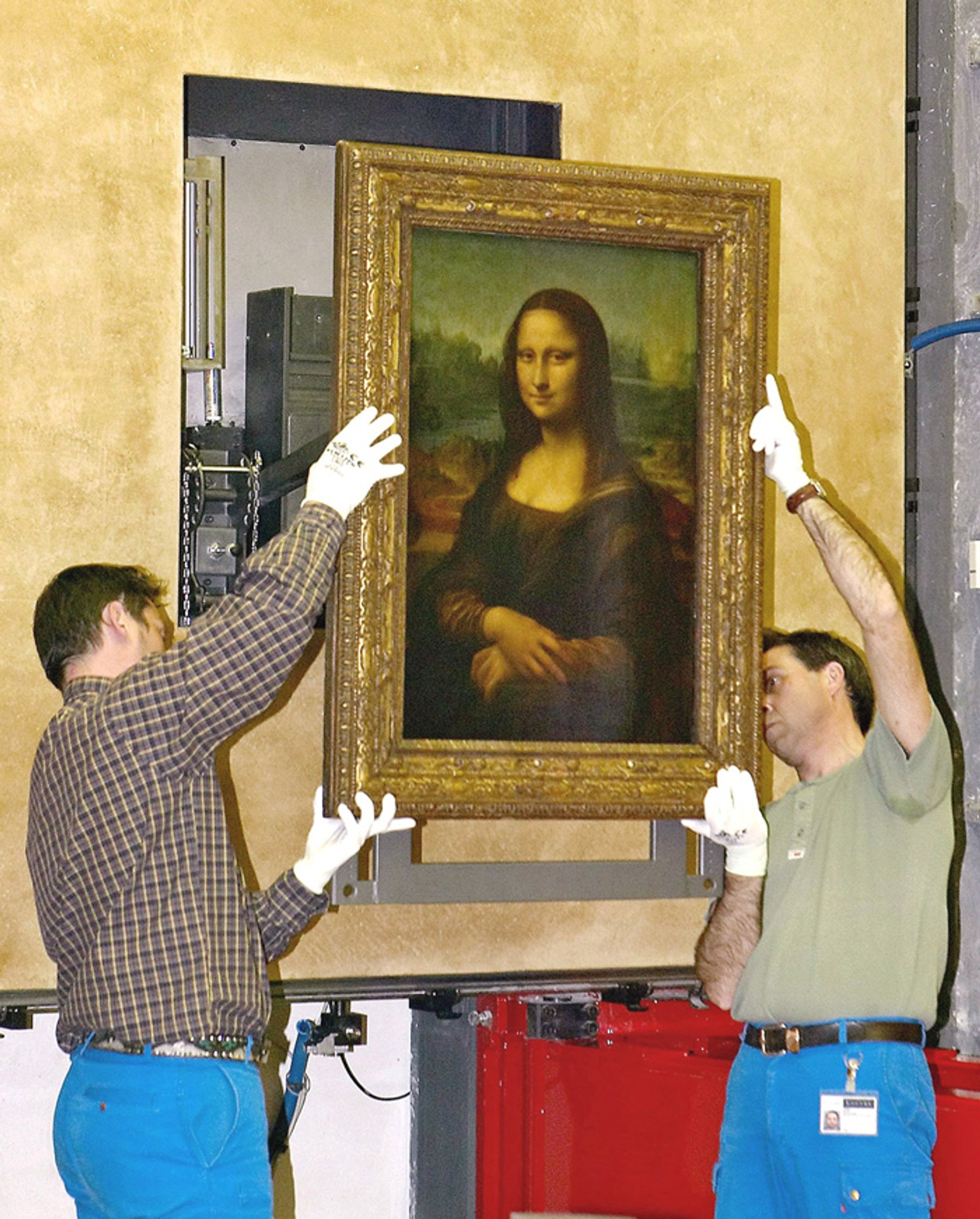 Pracovníci parížskeho Louvra vešajú svetoznámy obraz Leonarda da Vinciho Mona Lisa. (archívna snímka)