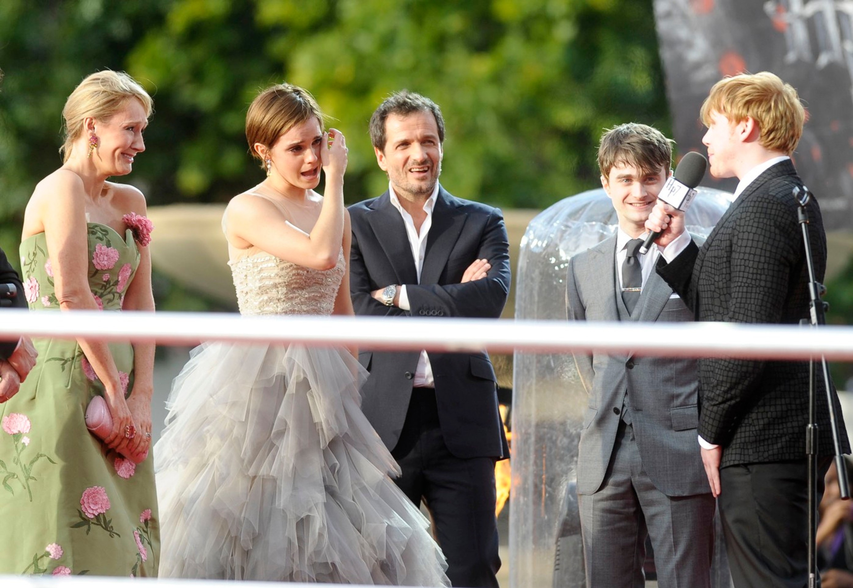 J. K. Rowlingová, Emma Watsonová a Daniel Radcliffe počúvajú príhovor Ruperta Grinta počas premiéry filmu Harry Potter a Dary smrti - 2.