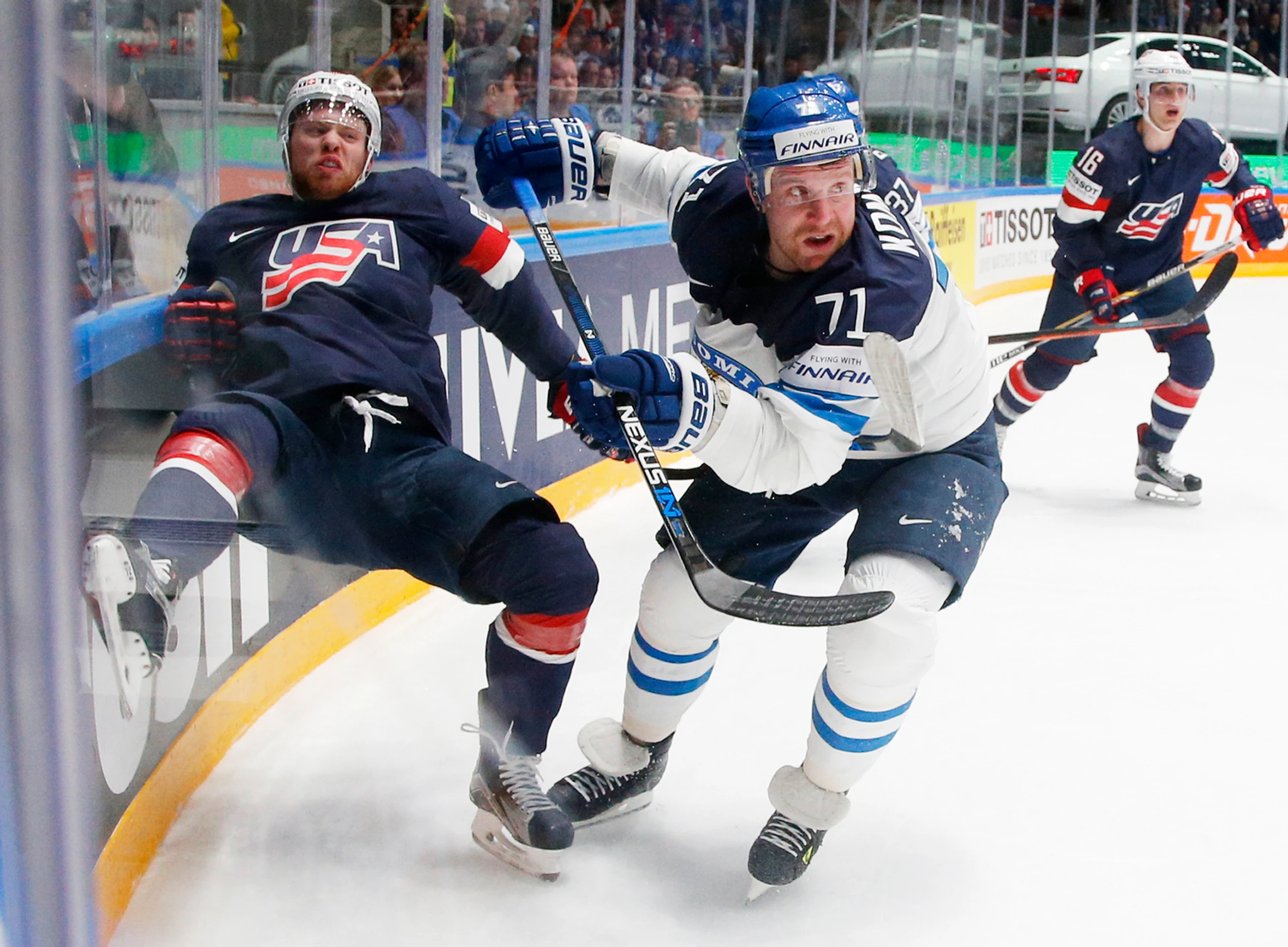Fínsky útočník Leo Komarov (v bielom) v súboji pri mantineli proti americkému protihráčovi T.J. Compheremovi počas duelu na MS v