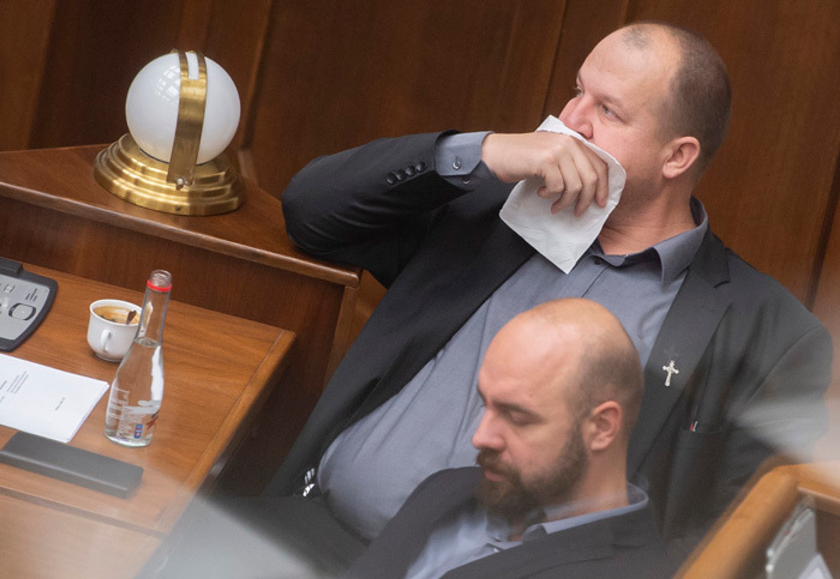 Peter Krupa si prekrýva tvár papierovou vreckovkou a dole Andrej Medvecký (obaja ĽSNS).