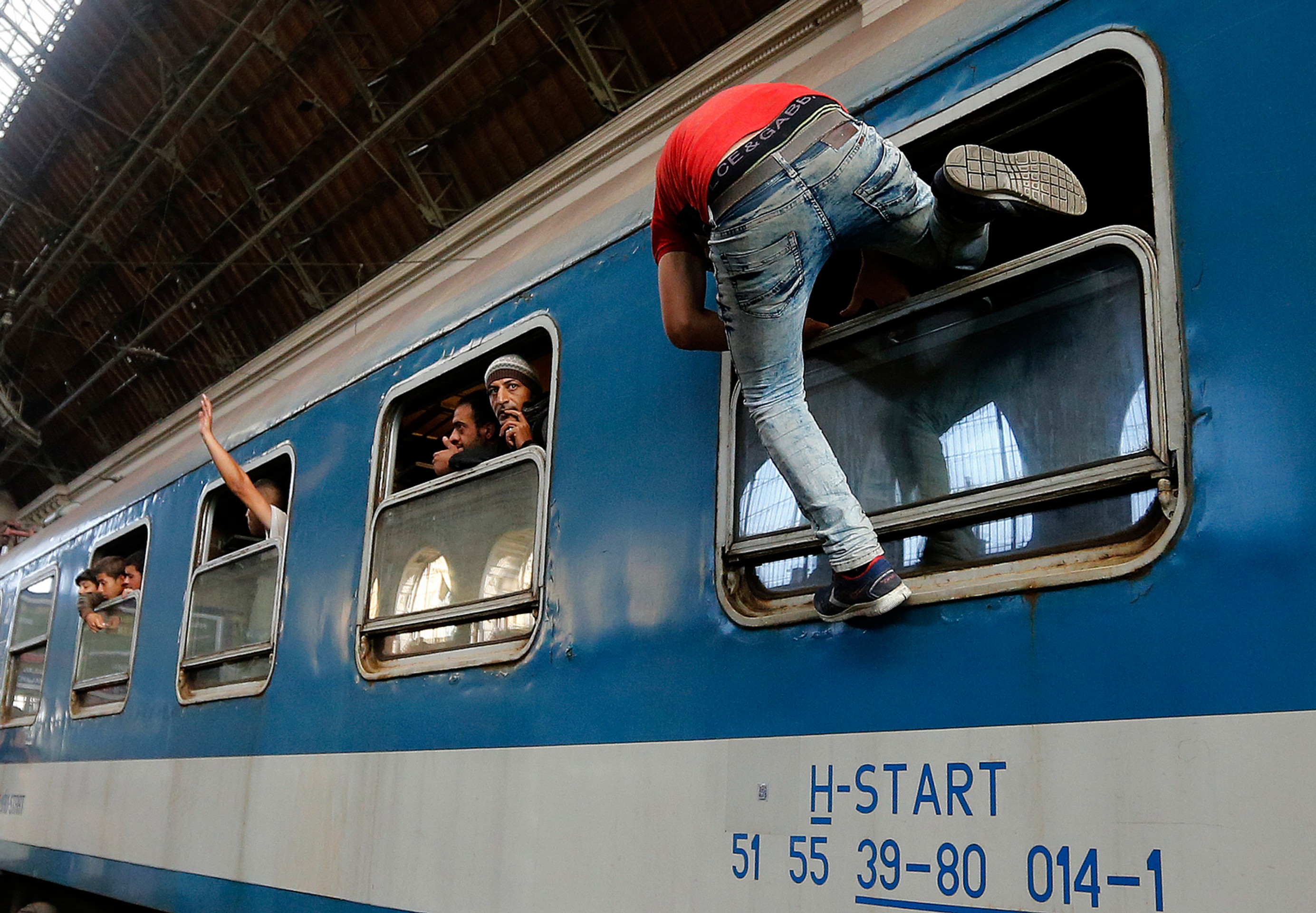Migranti sa snažia nastúpiť do vlaku v Budapešti.