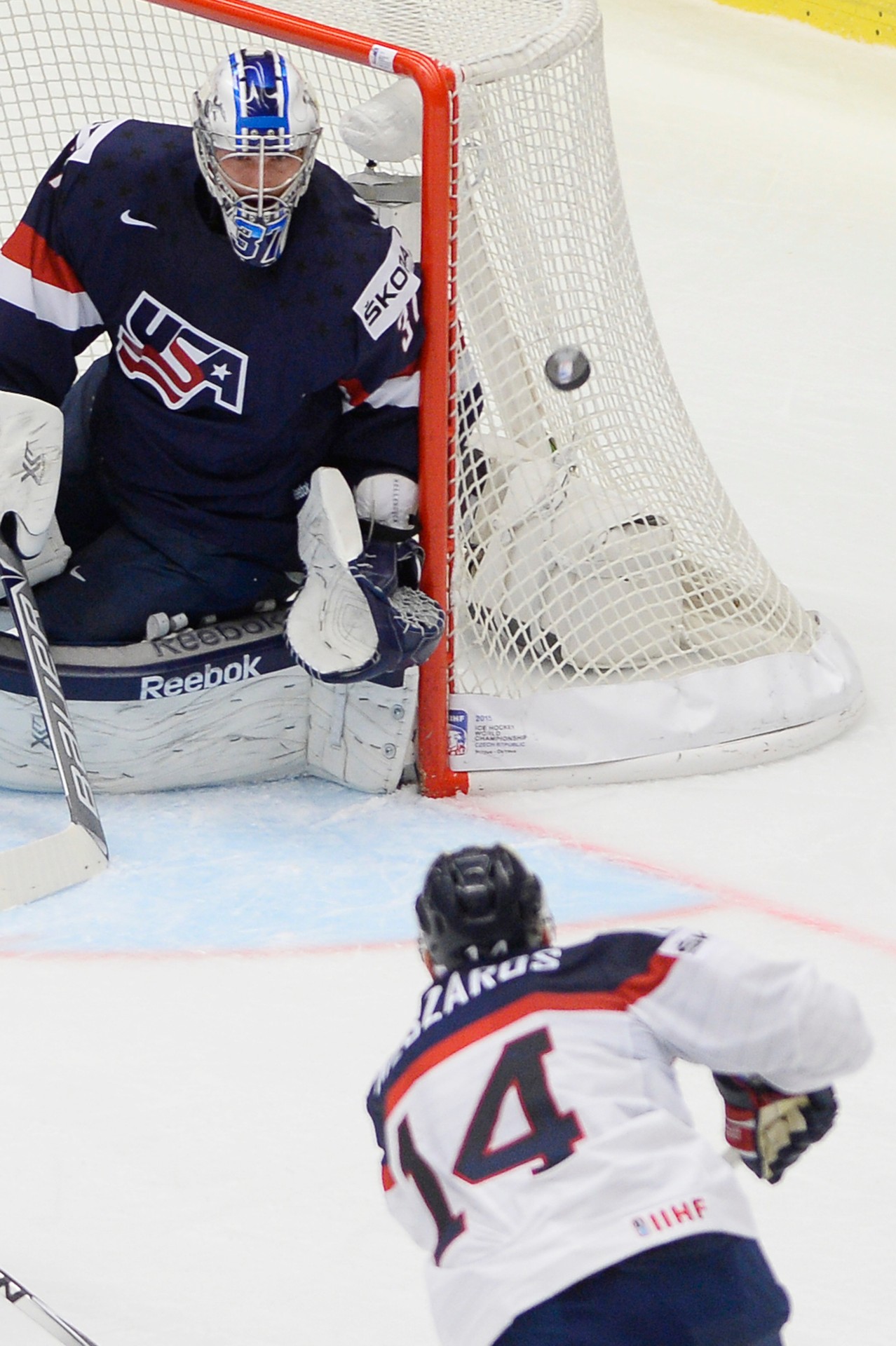 Na snímke dole Andrej Meszároš (Slovensko) a brankár Connor Hellebuyck (USA)