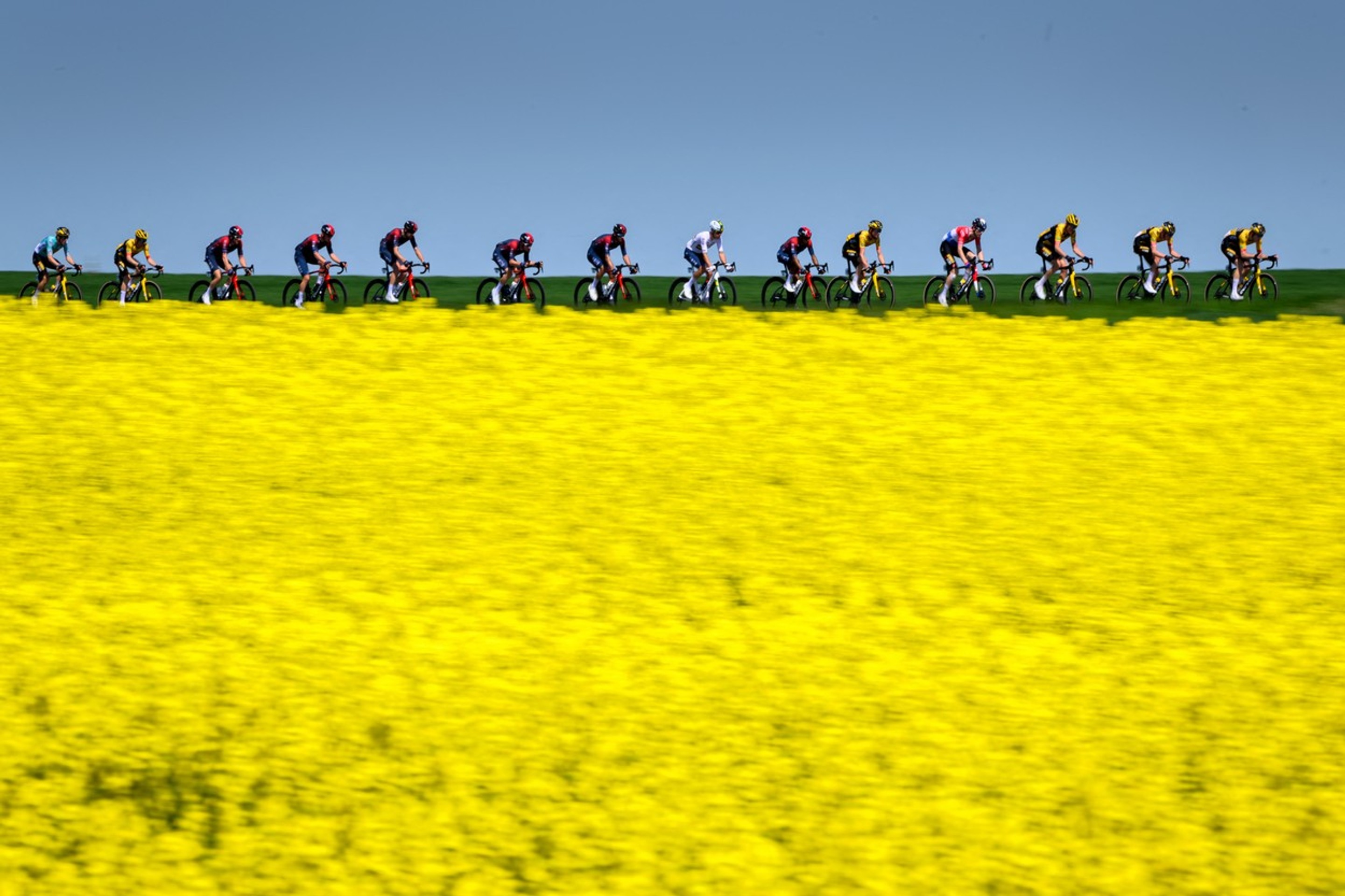 Skupina jazdcov prechádza okolo švajčiarskej dediny Echallens počas 4. etapy cyklistických pretekov Tour de Romandie.