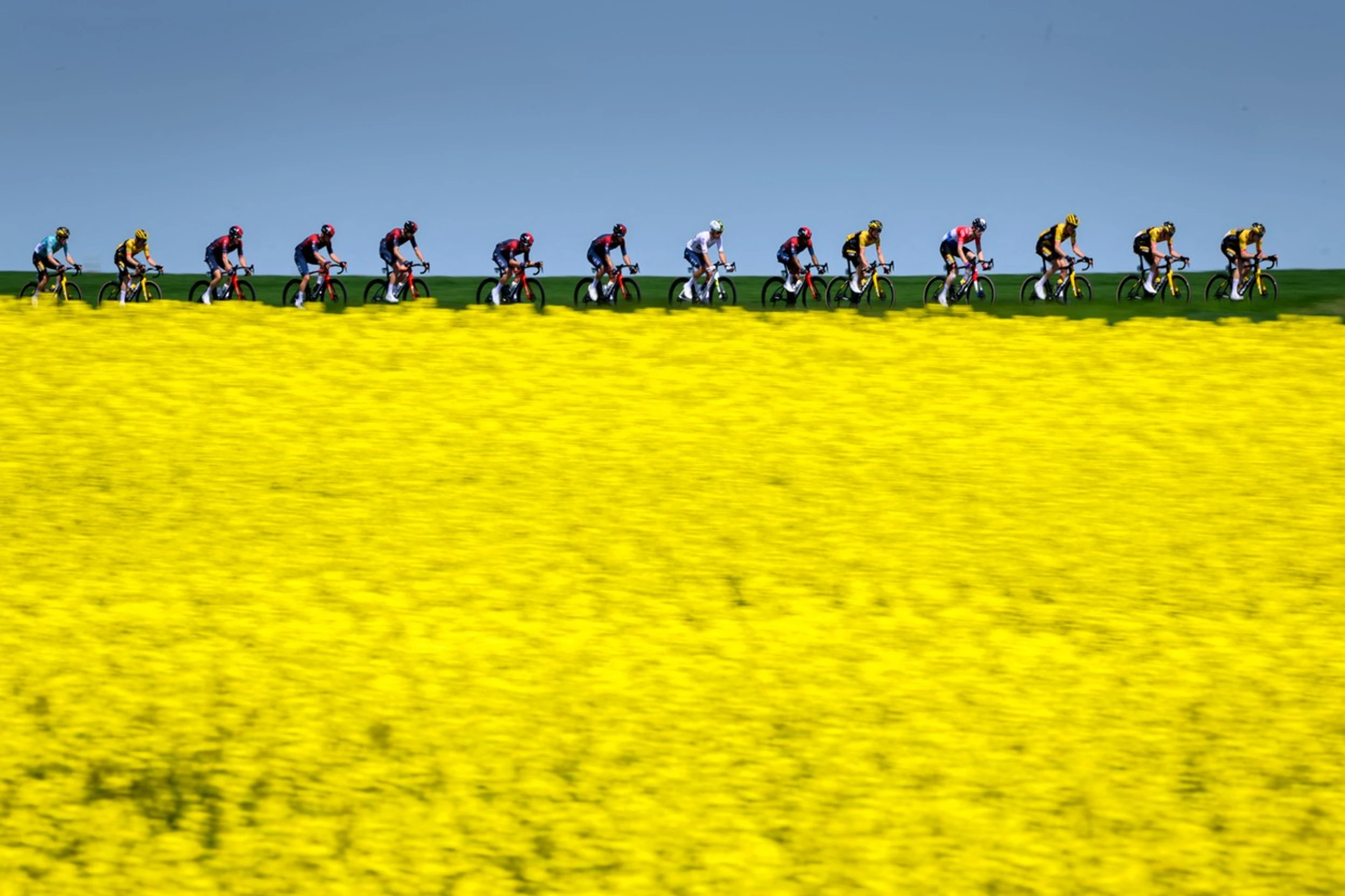 Skupina jazdcov prechádza okolo švajčiarskej dediny Echallens počas 4. etapy cyklistických pretekov Tour de Romandie.