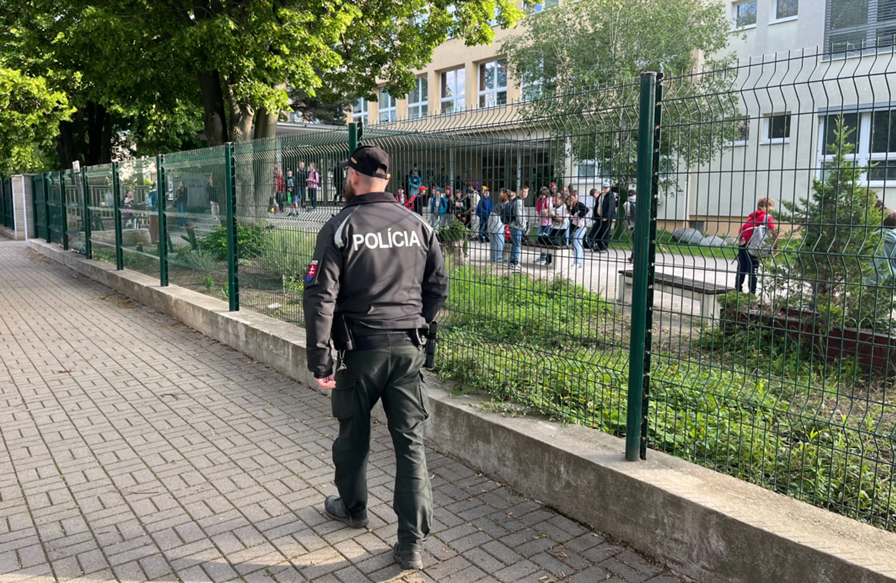 Policajt hliadkuje pred školou v Ivanke pri Dunaji.