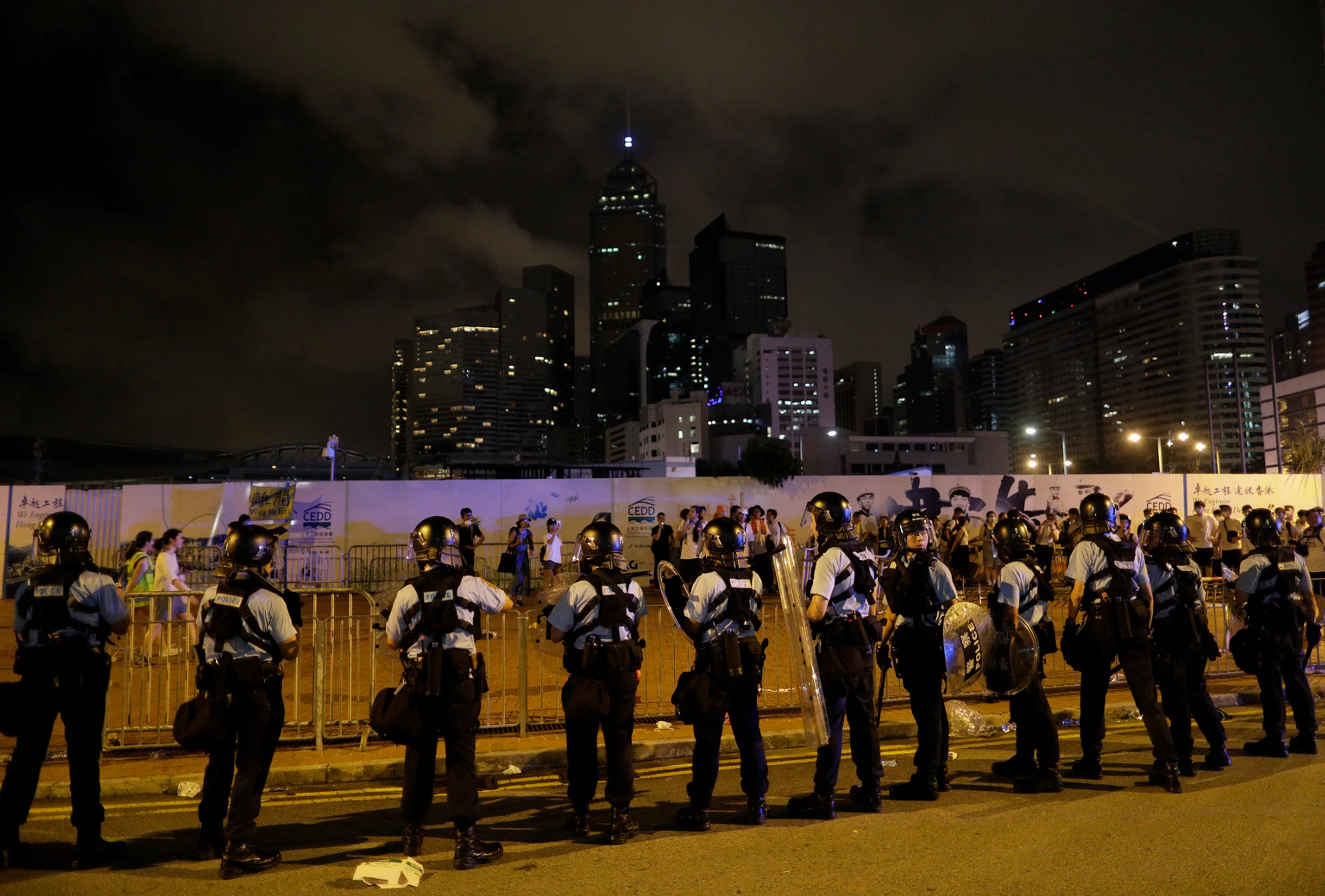 Policajti v Hongkongu zatýkajú počas protestu muža.