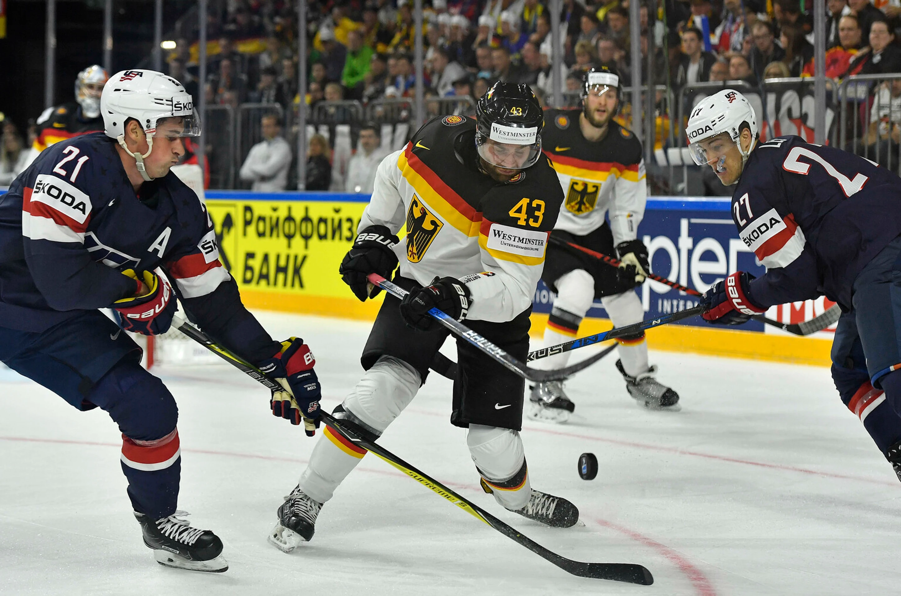 Američania Dylan Larkin (vľavo) a Anders Lee stíhajú Nemca Gerrita Fausera na MS 2017.