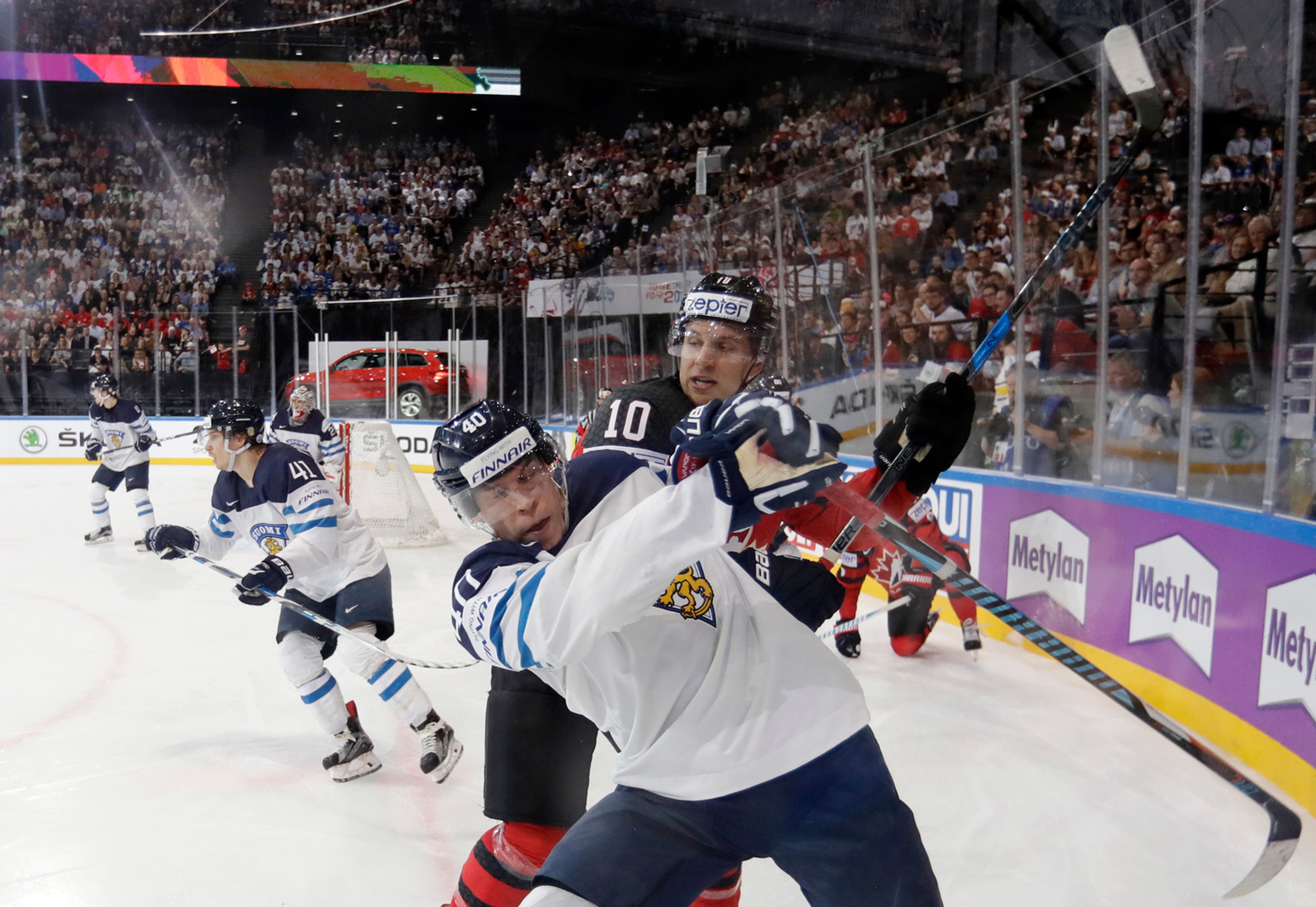 Kanaďan Brayden Schenn (vzadu) v nešetrnom súboji pri mantineli s Fínom Tomim Sallinenom v dueli MS 2017.