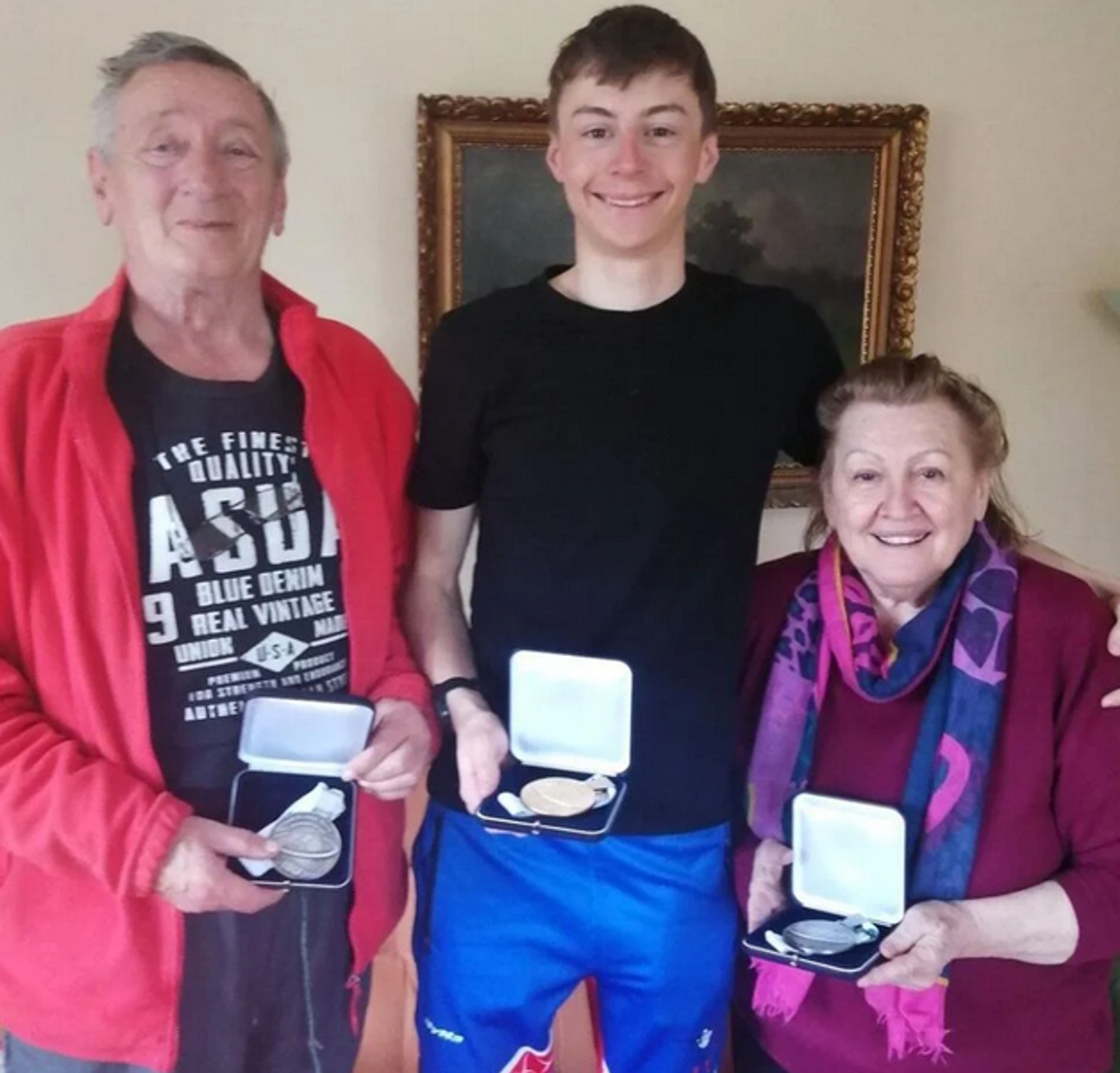 Jakub pózuje s medailami spolu s babkou Jankou a dedom Ondrejom.