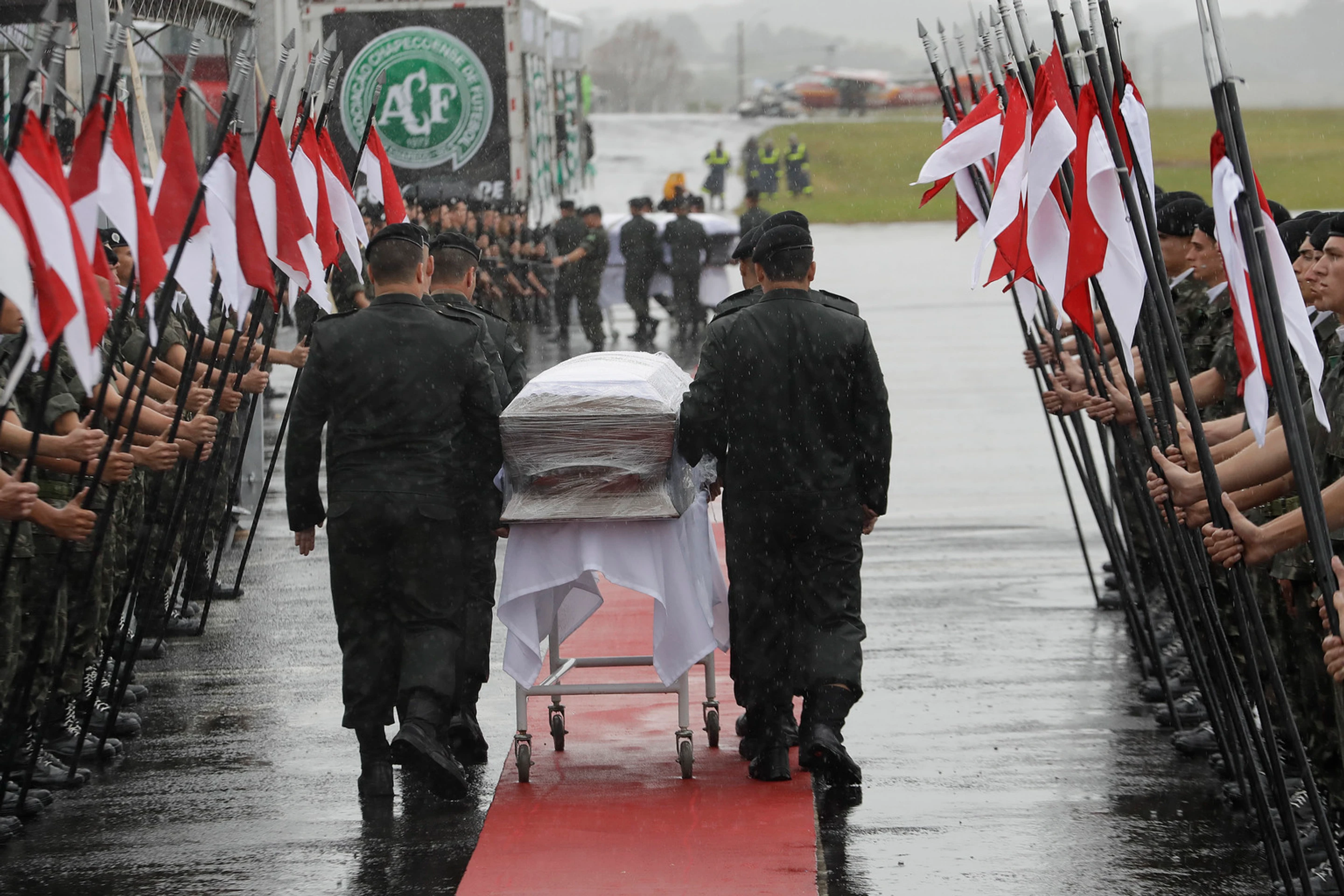 Vojaci kráčajú s rakvami tiel leteckej katastrofy v kolumbijskom Medellíne.