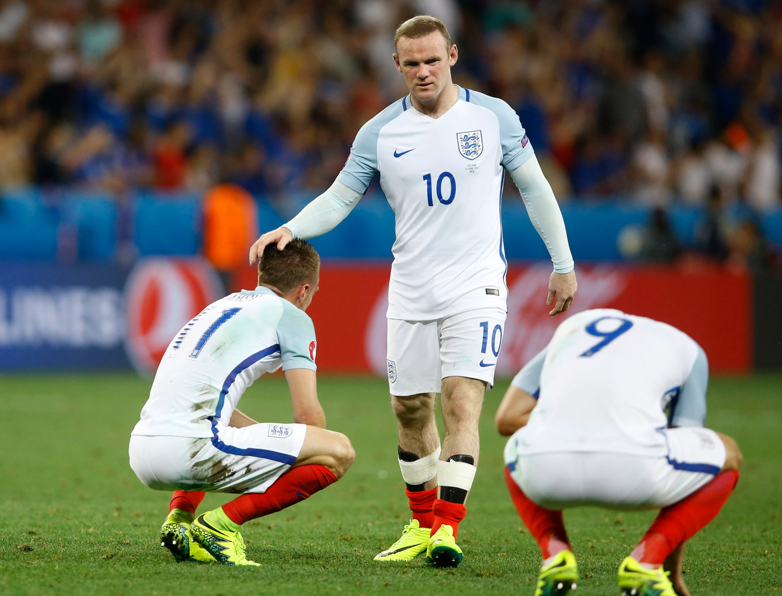 Anglický futbalista Wayne Rooney utešuje svojich spoluhráčov po osemfinálovej prehre s Islandom na ME.