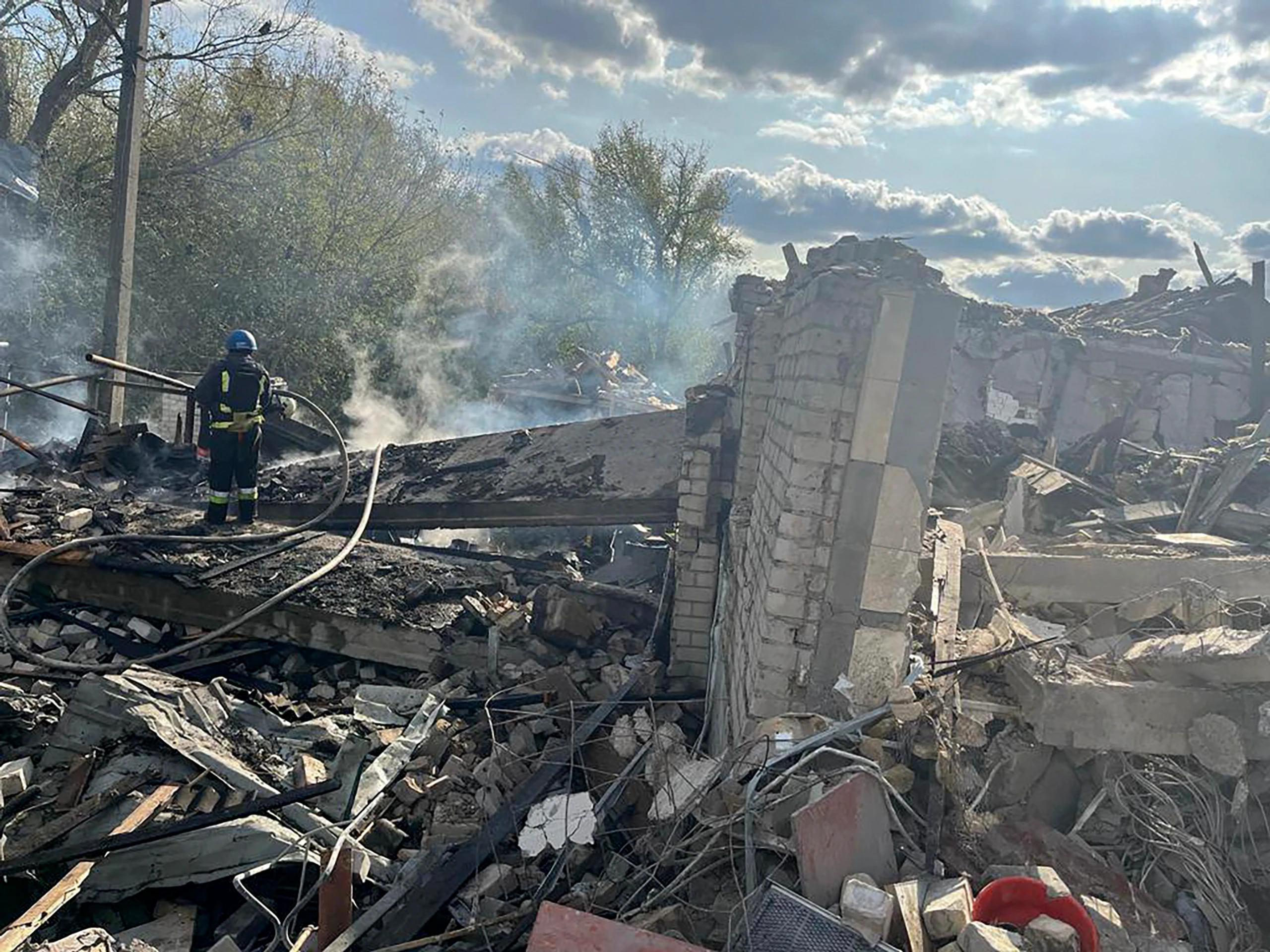 Na snímke hasiči hasia požiar po ruskom raketovom útoku na dedinu Hroza v Charkovskej oblasti