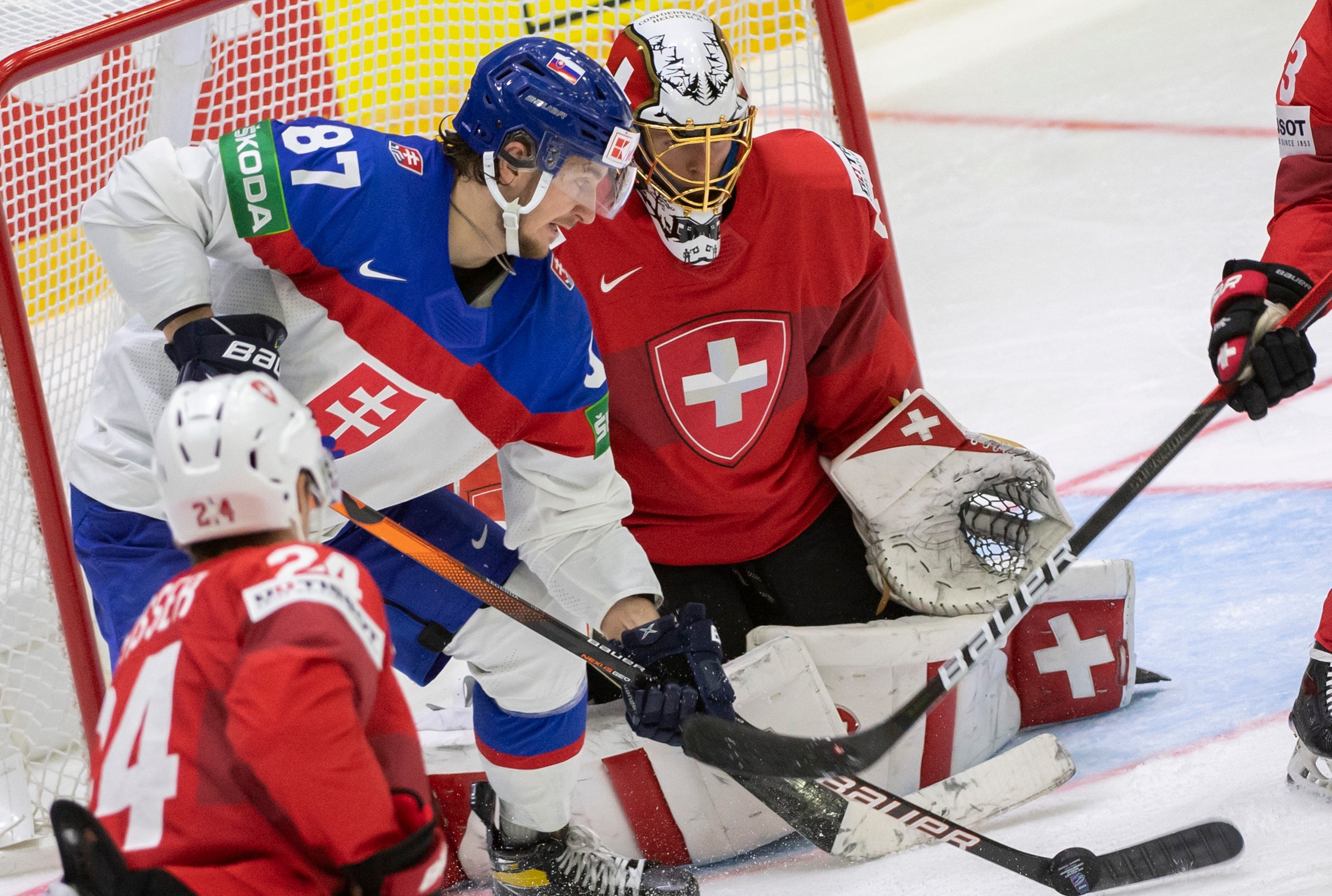 Na snímke vľavo Pavol Regenda (Slovensko) a vpravo brankár Leandro Genoni (Švajčiarsko).