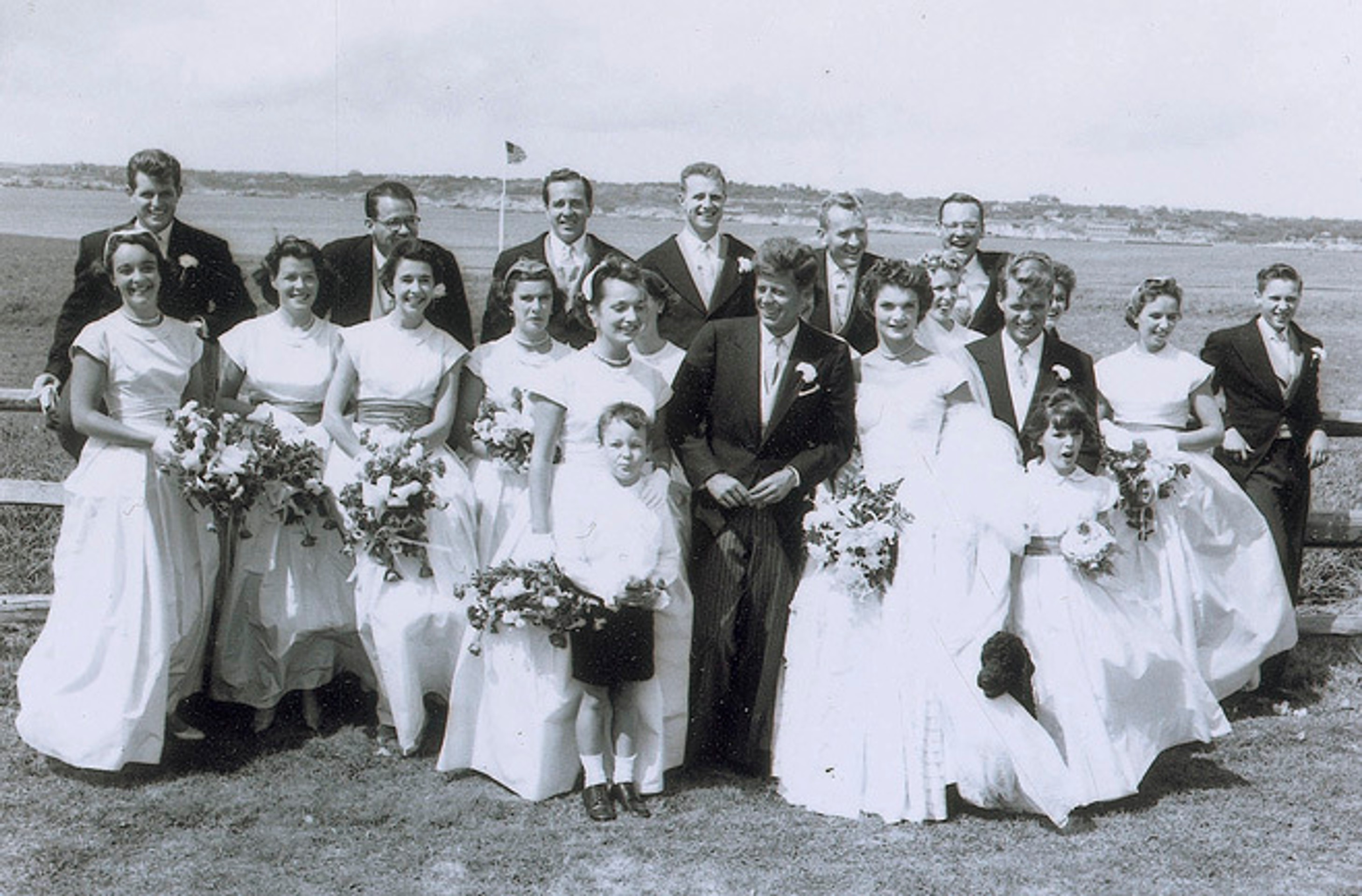 John F. Kennedy a manželka Jacqueline pózujú so sobášnymi hosťami v americkom Newporte.