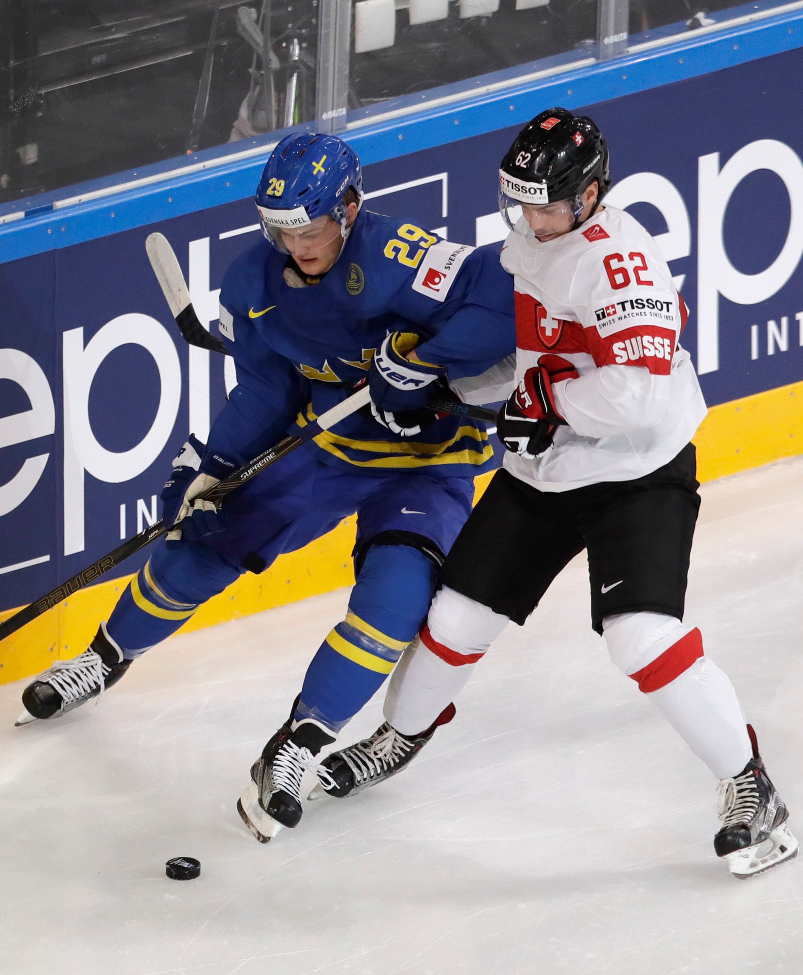 William Nylander (vľavo) zo Švédska si prikrýva puk pred Švajčiarom Denisom Malginom vo štvrťfinále MS 2017.