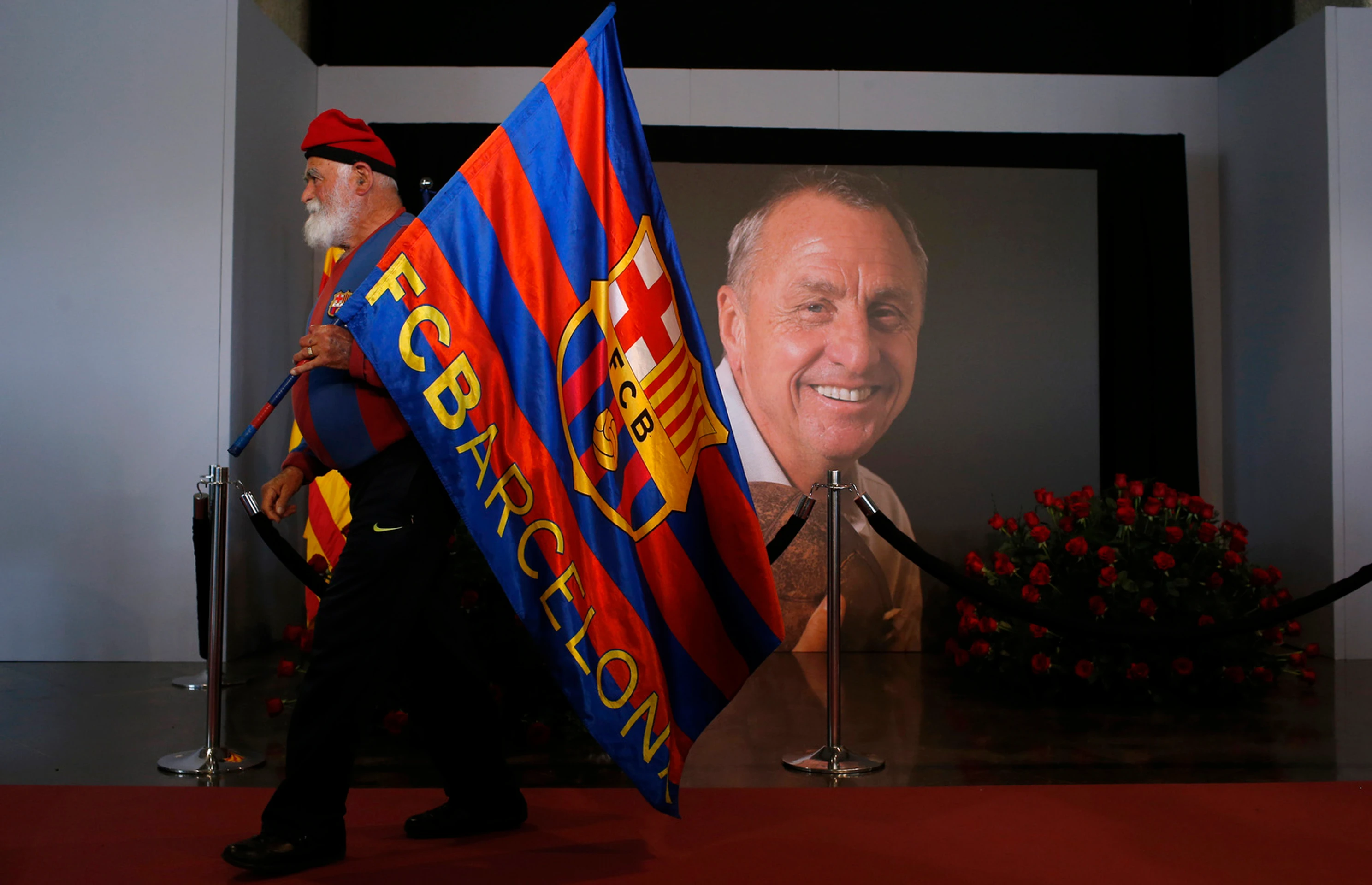 Fanúšik drží vlajku na počesť legendárneho holandského futbalistu, kapitána a trénera FC Barcelona Johana Cruyffa. 29. marca