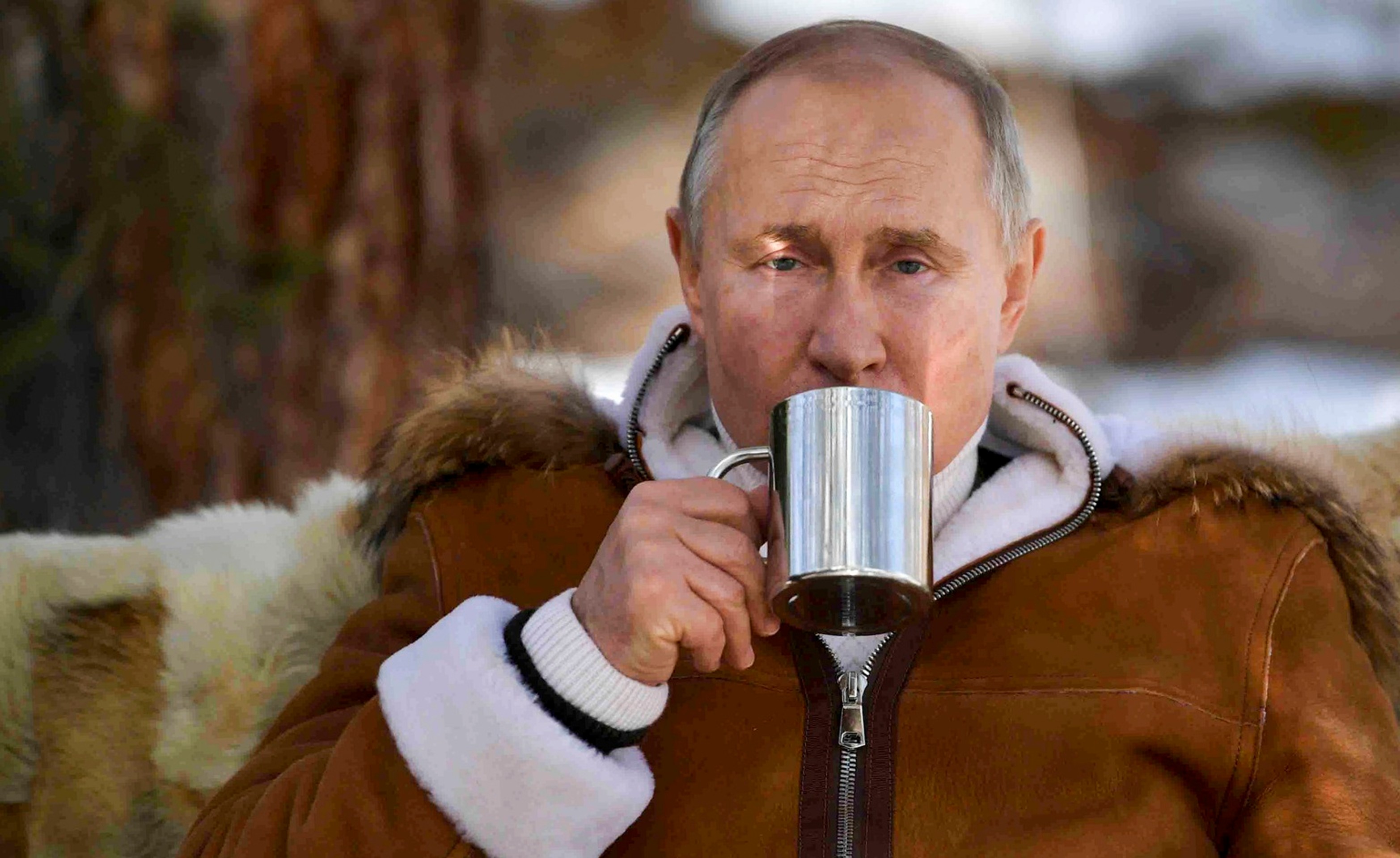 Ruský prezident Vladimir Putin pije zo šálky v rámci prestávky počas víkendovej návštevy tajgy na Sibíri 21. marca 2021..jpg