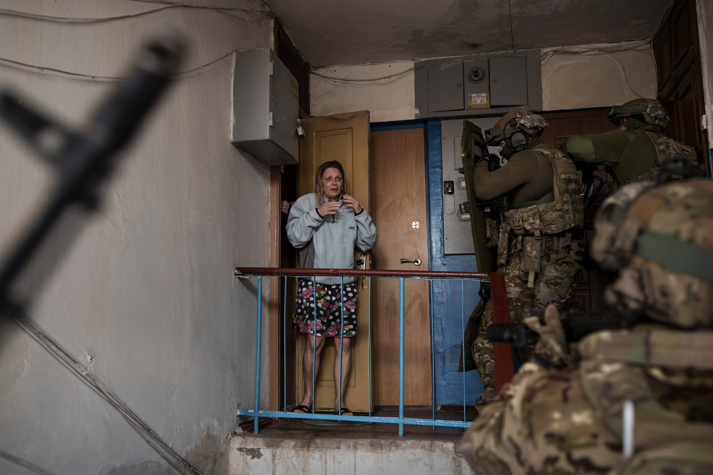 Vystrašená žena sa pozerá na príslušníkov ukrajinskej tajnej služby SBU, ktori prišli zadržať muža podozrivého z kolaborácie s Ruskom.